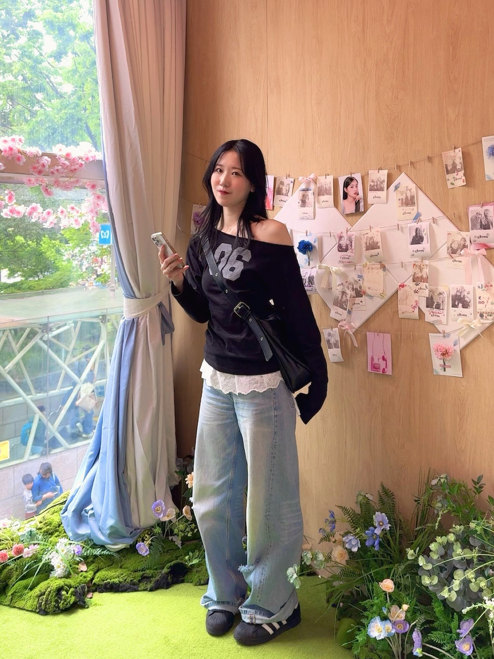 ブラック系のTシャツ/カットソー、ブルー系のデニムパンツ、ブラック系のスニーカーを着用したレディースの春コーディネートの2枚目の写真