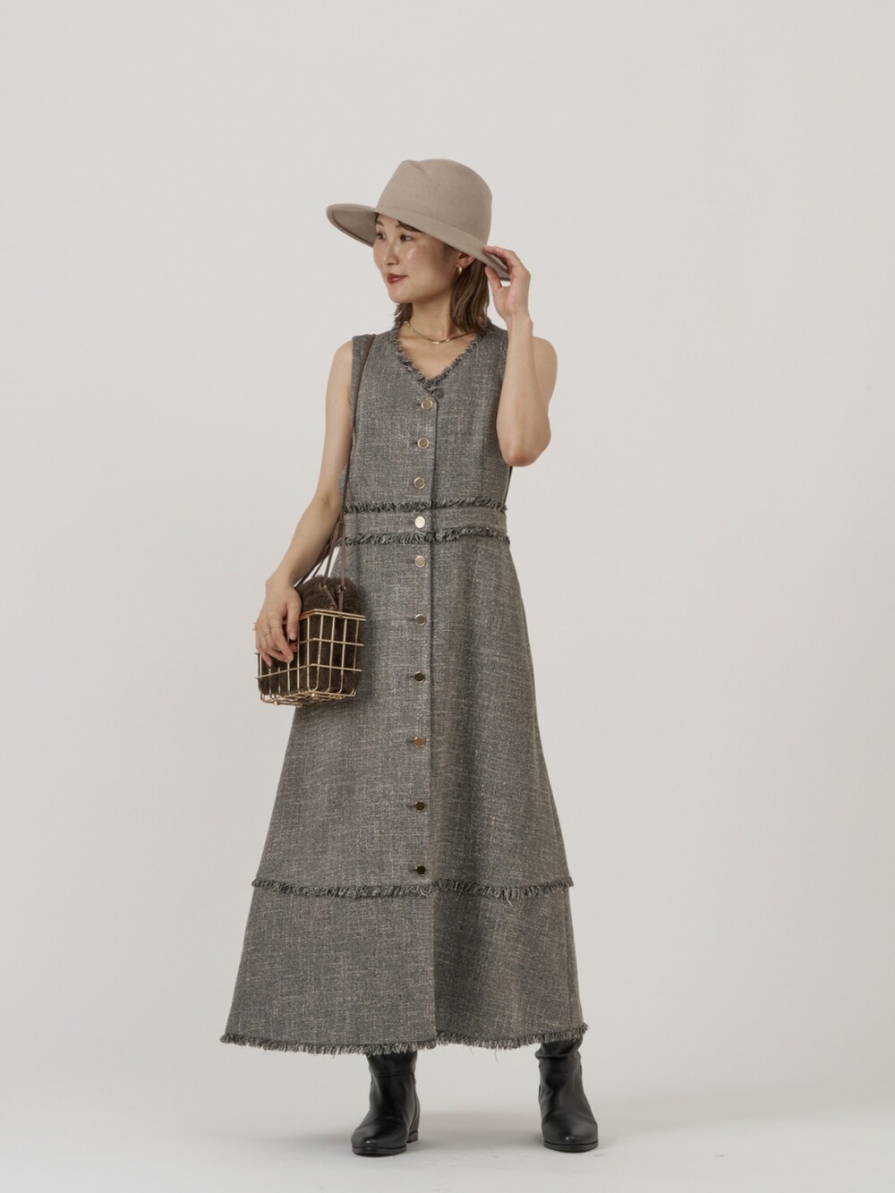 グレー系のベスト、ブラック系のワンピースを着用したレディースの秋コーディネートの3枚目の写真