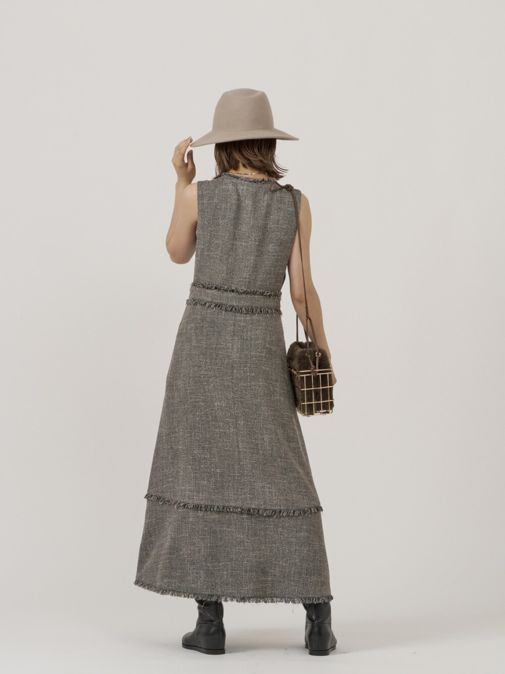 グレー系のベスト、ブラック系のワンピースを着用したレディースの秋コーディネートの4枚目の写真