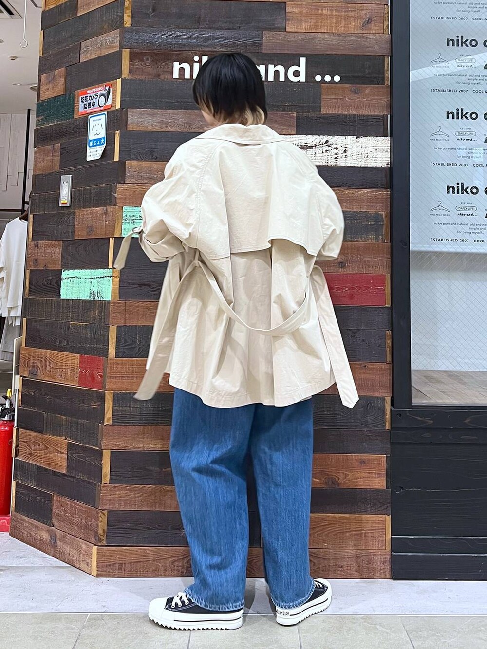 ベージュ系のトレンチコート、ベージュ系のシャツ/ブラウス、ブルー系のデニムパンツを着用したレディースの春コーディネートの3枚目の写真