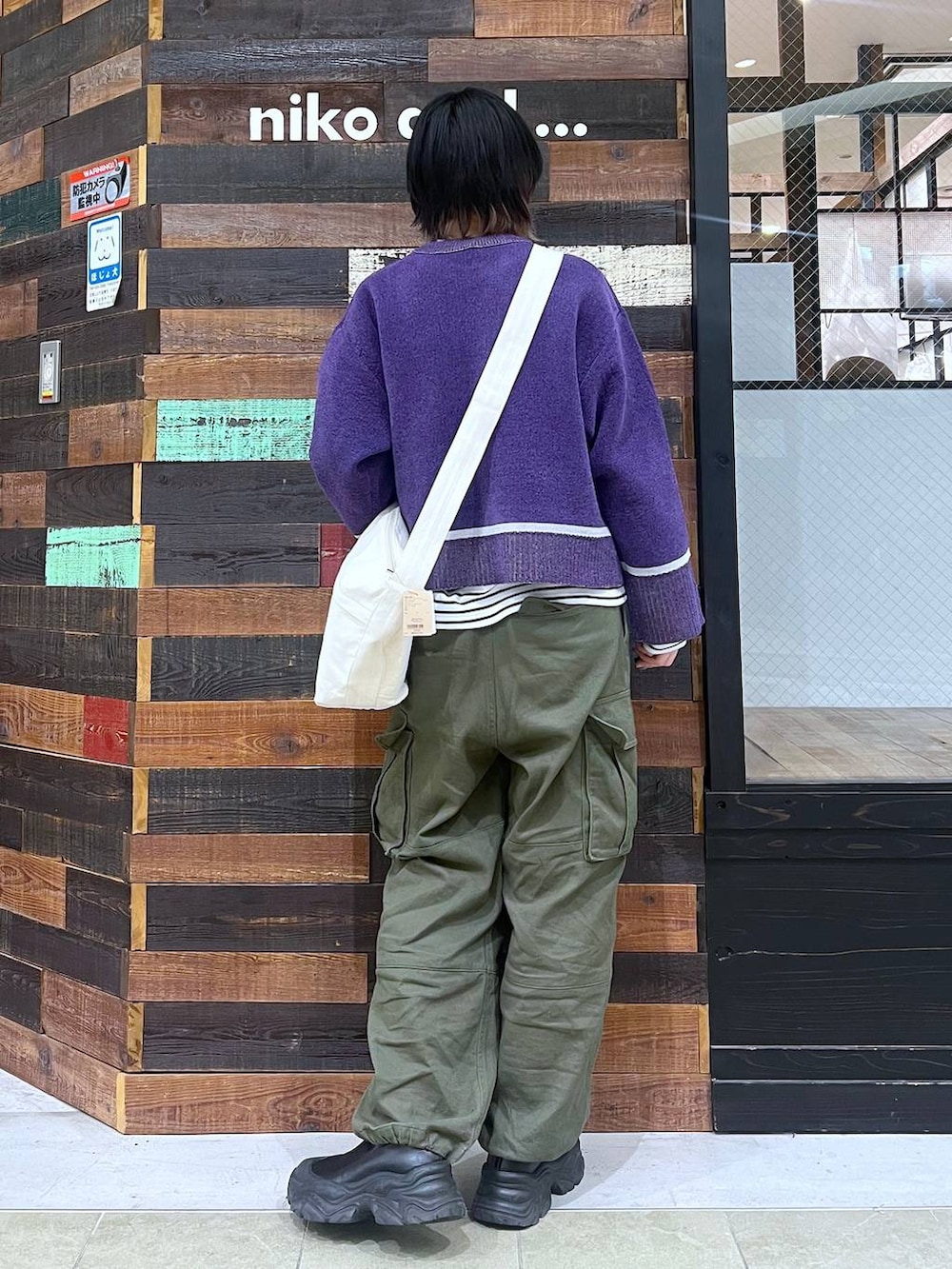 ブラウン系のショルダーバッグ、ブラック系のブーツ、グリーン系のその他パンツを着用したレディースの冬コーディネートの3枚目の写真