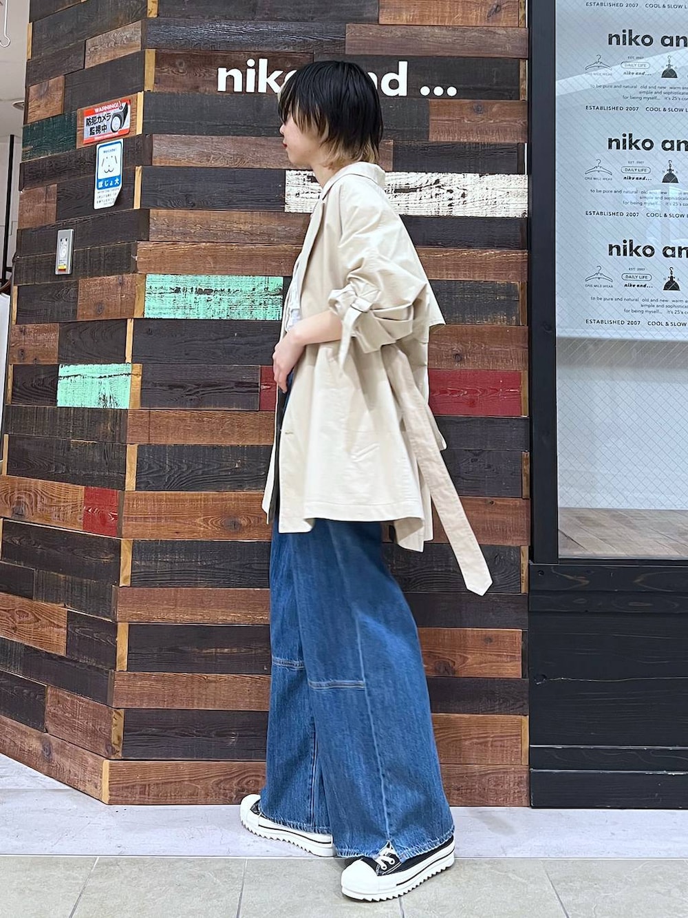 ベージュ系のトレンチコート、ベージュ系のシャツ/ブラウス、ブルー系のデニムパンツを着用したレディースの春コーディネートの2枚目の写真