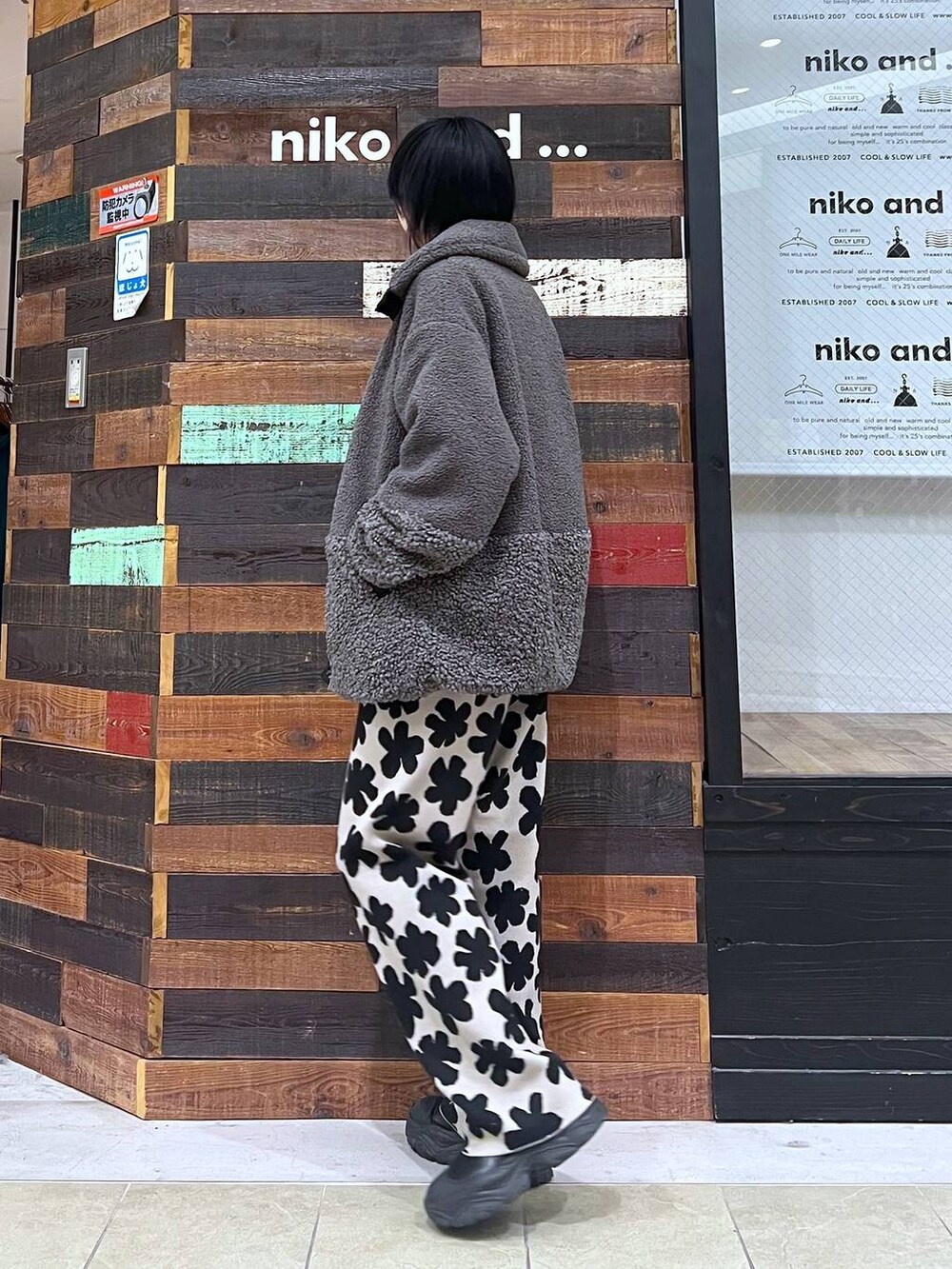 グレー系のその他アウター、ブラック系のブーツ、ブラック系のニット/セーターを着用したレディースの冬コーディネートの2枚目の写真