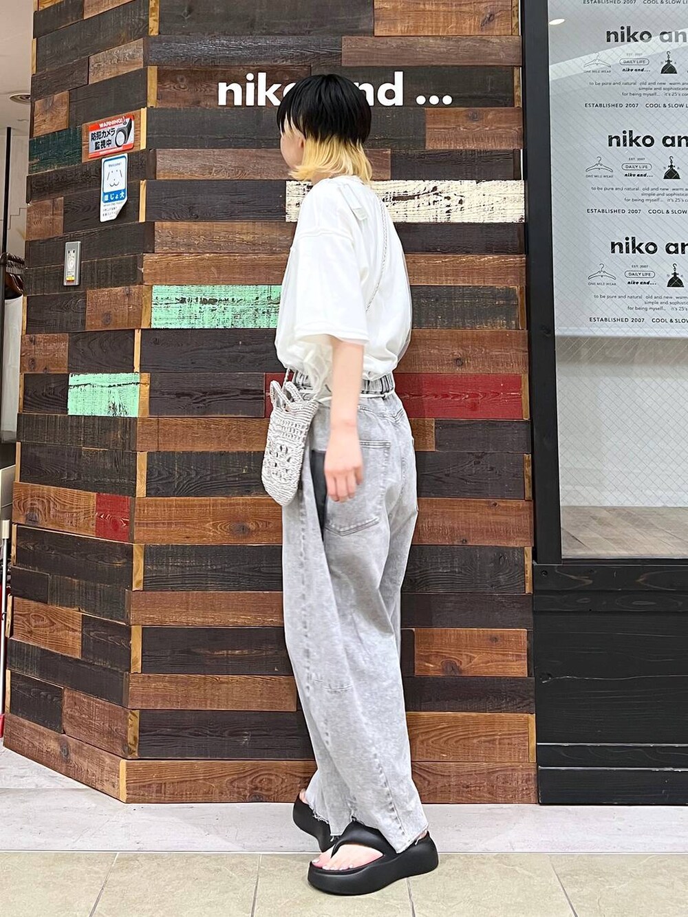 グレー系のショルダーバッグ、ブラック系のサンダル、グレー系のデニムパンツを着用したレディースの夏コーディネートの2枚目の写真