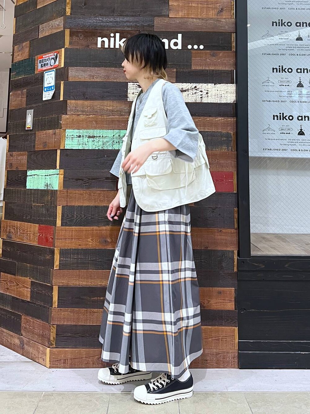 ベージュ系のベスト、ブラック系のショルダーバッグ、グレー系のTシャツ/カットソーを着用したレディースの春コーディネートの2枚目の写真