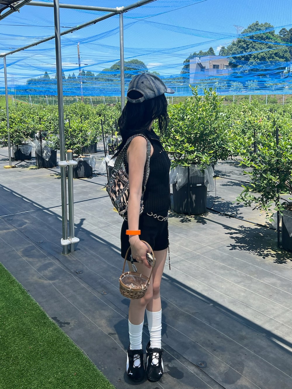 ブラック系のスニーカー、ブラック系のタンクトップ、シルバー系のベルトを着用したレディースの夏コーディネートの2枚目の写真
