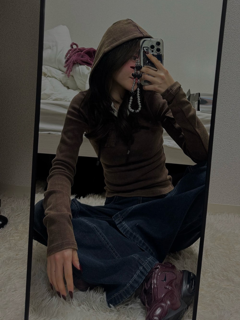 ブラウン系のTシャツ/カットソー、ブルー系のデニムパンツ、レッド系のスニーカーを着用したレディースの冬コーディネートの2枚目の写真