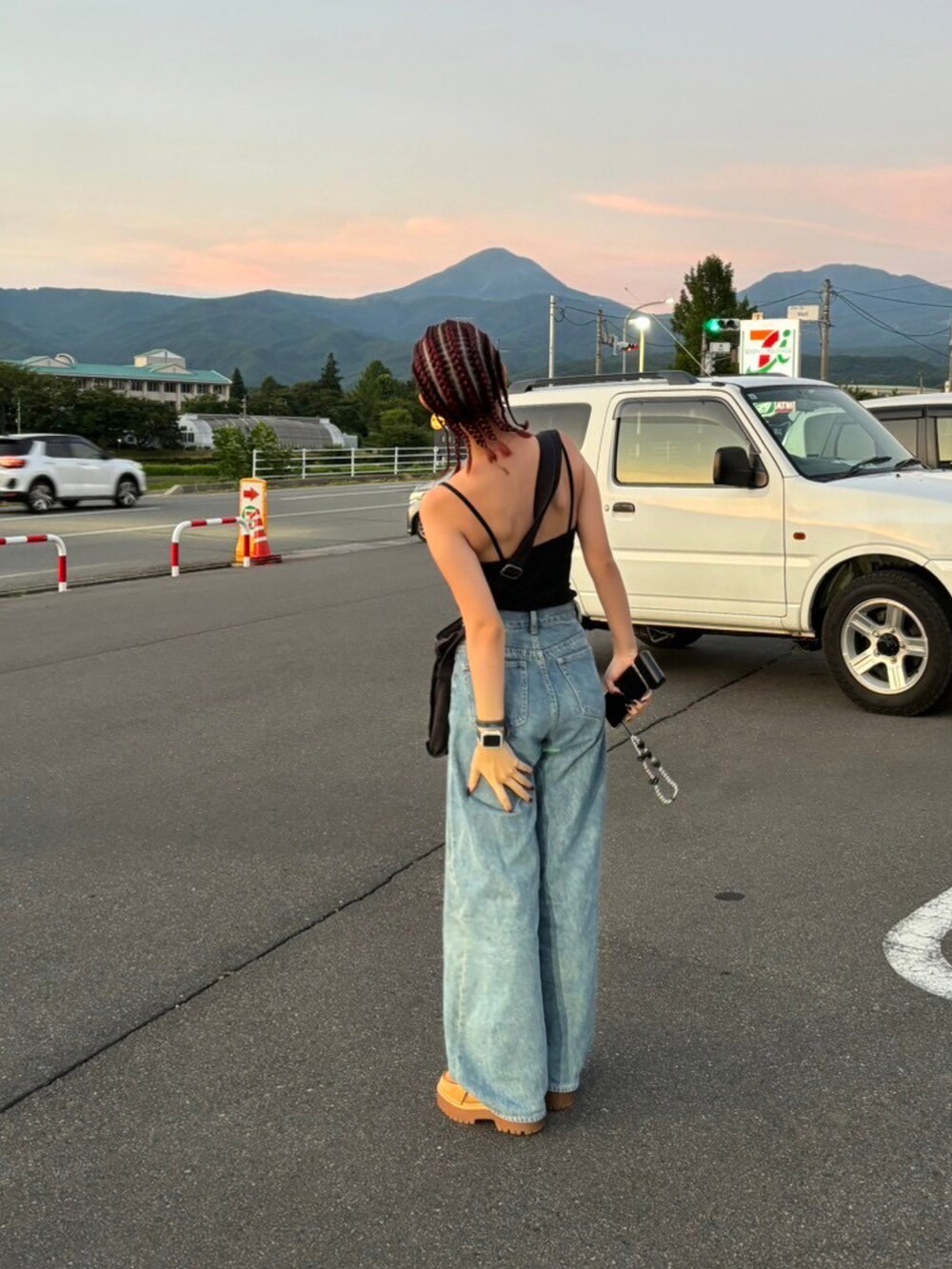 ブルー系のデニムパンツ、ブラウン系のモカシン/デッキシューズ、ブラック系のショルダーバッグを着用したレディースの秋コーディネートの2枚目の写真