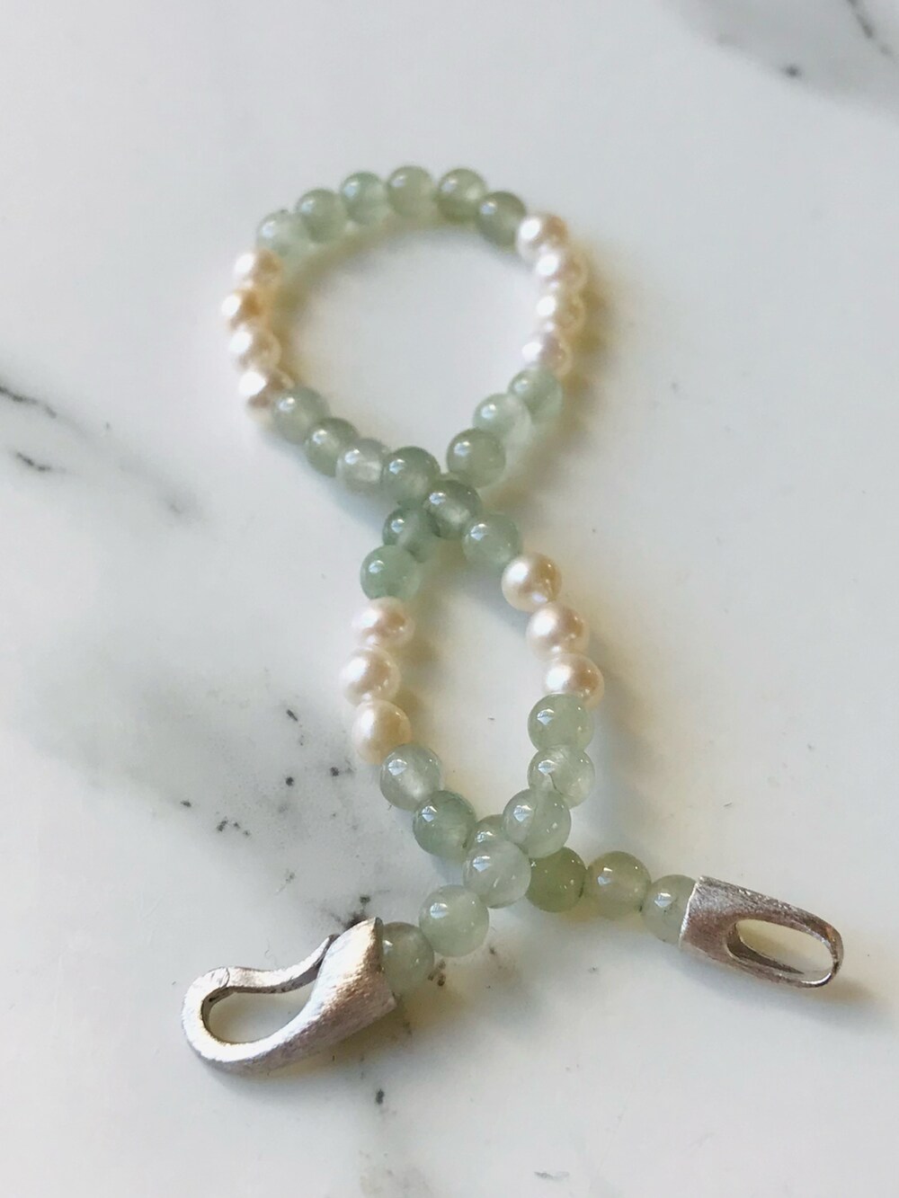 グリーン系のブレスレットを着用したレディースの冬コーディネートの2枚目の写真