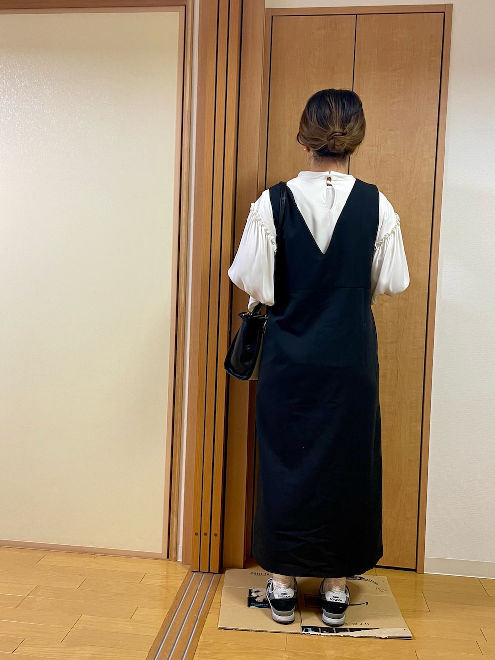 ブラック系のスニーカー、ブラック系のショルダーバッグ、ブラック系のジャンパースカートを着用したレディースの秋コーディネートの3枚目の写真