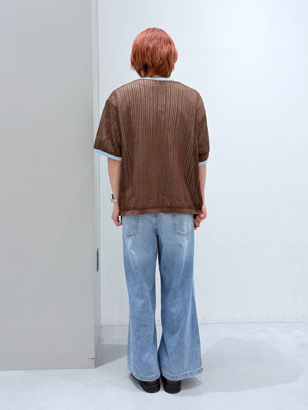 ホワイト系のTシャツ/カットソー、ブルー系のデニムパンツ、ブラウン系のニット/セーターを着用したメンズの春コーディネートの3枚目の写真