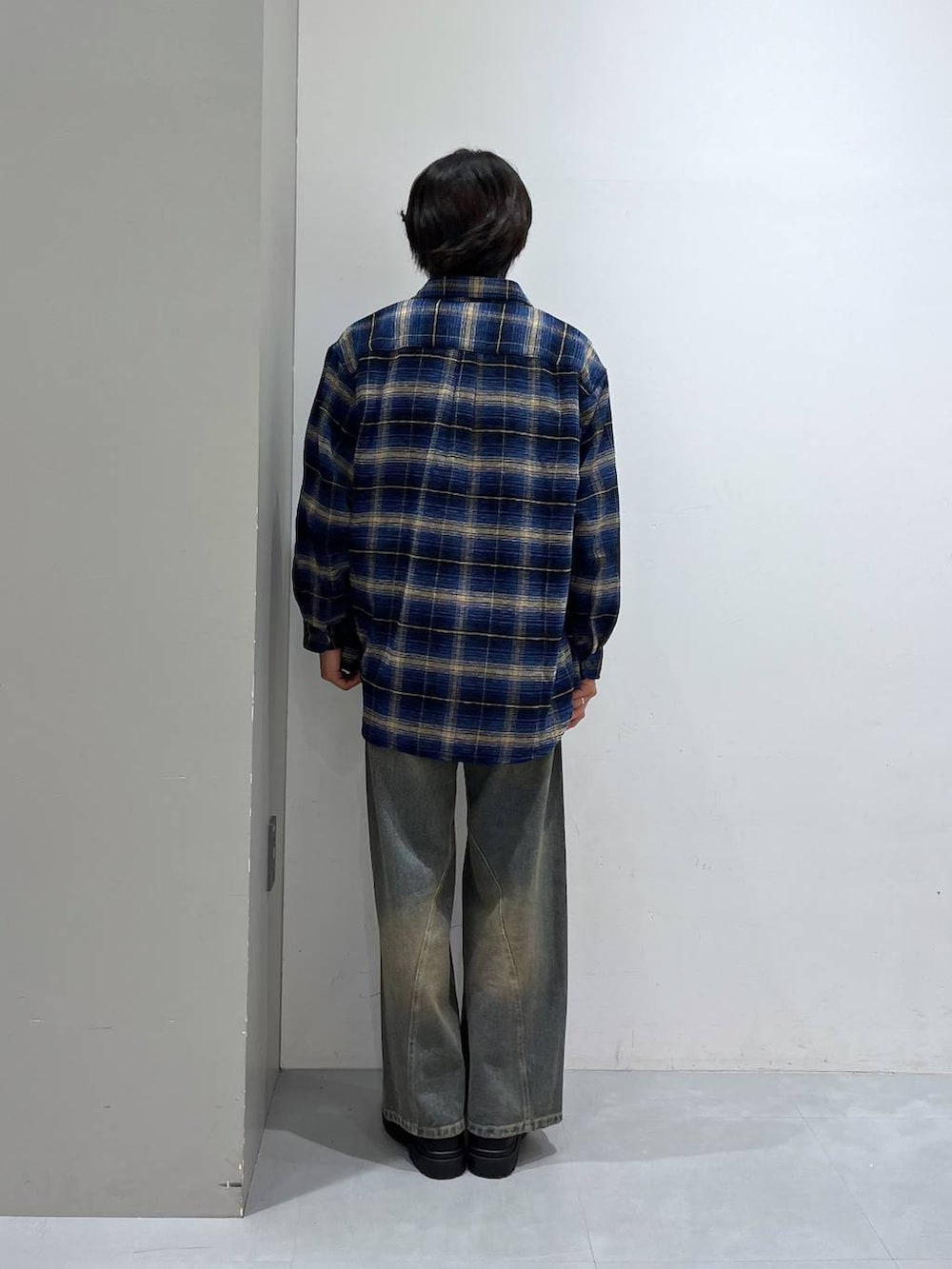 グレー系のTシャツ/カットソー、ブルー系のデニムパンツ、ブラック系のローファーを着用したメンズの秋コーディネートの3枚目の写真
