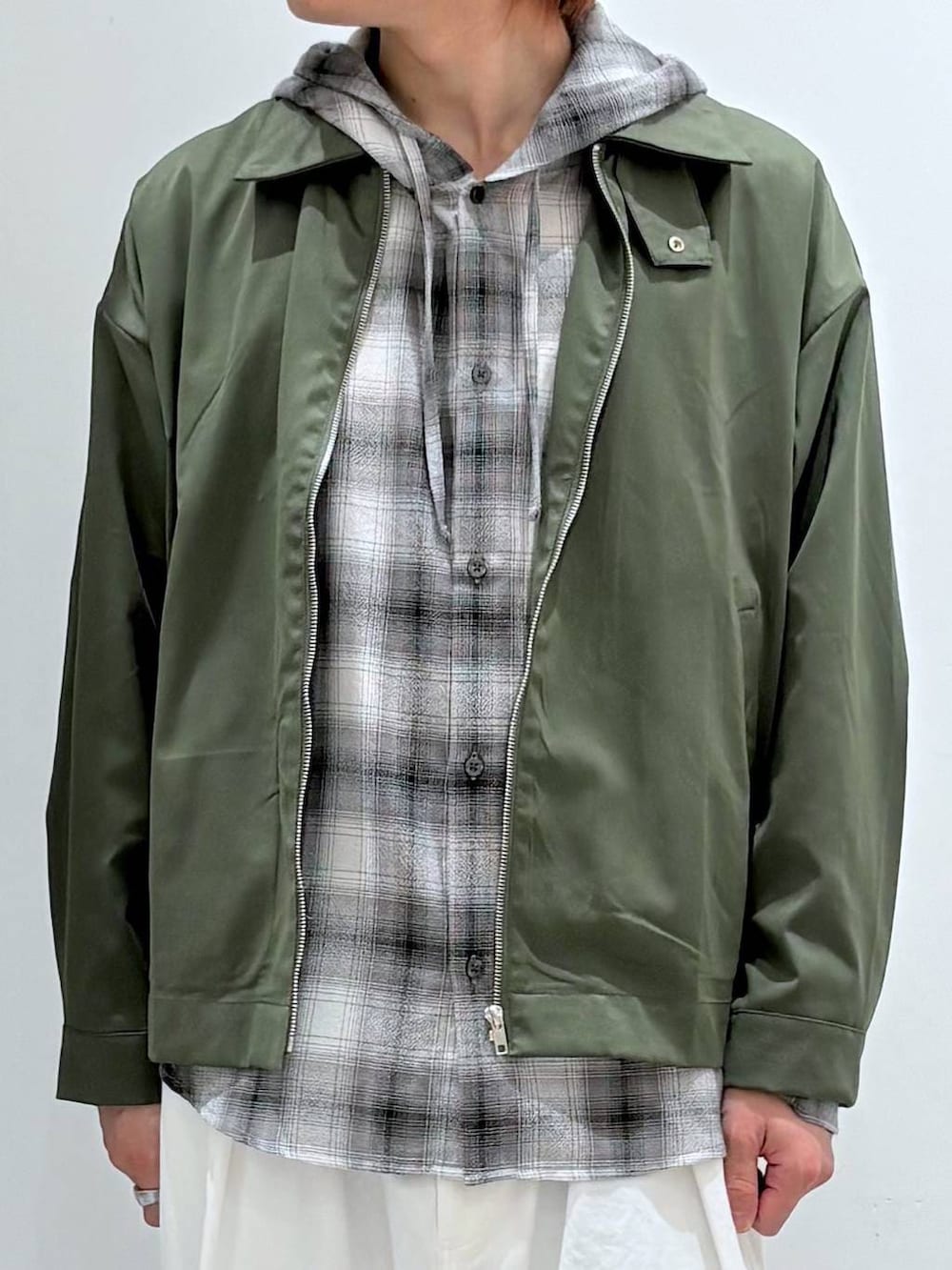 ホワイト系のチノパンツ、ブラック系のシャツ/ブラウス、グリーン系のブルゾンを着用したメンズの冬コーディネートの4枚目の写真