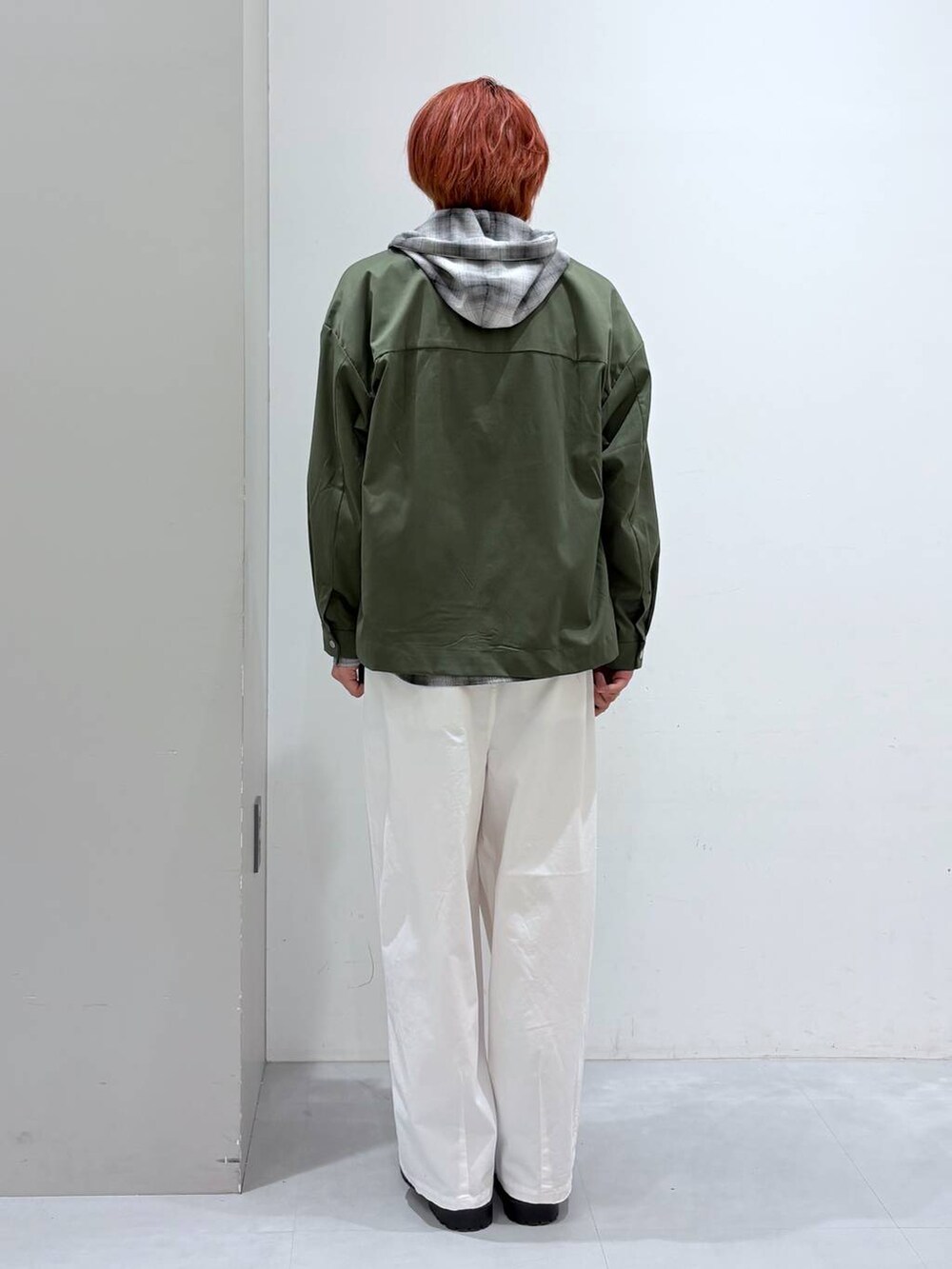 ホワイト系のチノパンツ、ブラック系のシャツ/ブラウス、グリーン系のブルゾンを着用したメンズの冬コーディネートの3枚目の写真