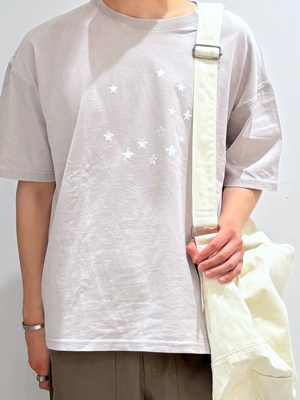 ベージュ系のショルダーバッグ、グレー系のその他パンツ、グレー系のTシャツ/カットソーを着用したメンズの春コーディネートの4枚目の写真
