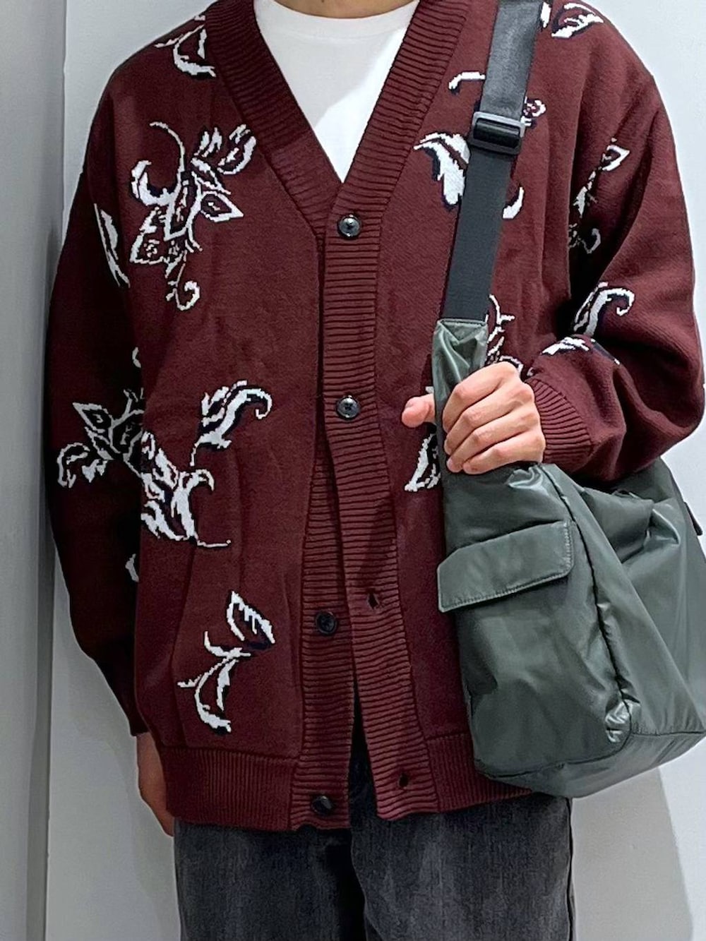 グリーン系のショルダーバッグ、グレー系のデニムパンツ、ブラウン系のローファーを着用したメンズの秋コーディネートの4枚目の写真