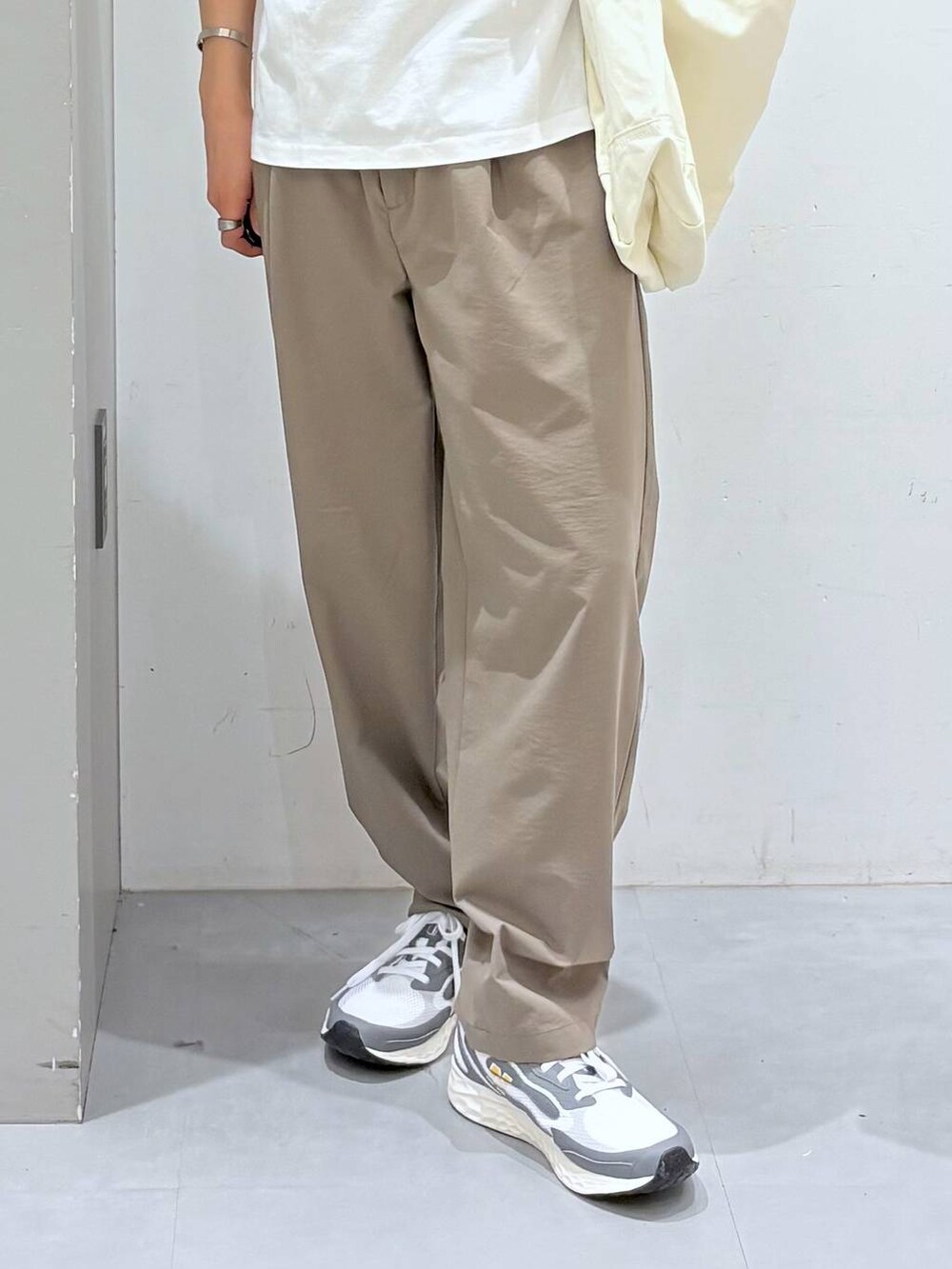 ベージュ系のショルダーバッグ、ベージュ系のその他パンツ、ホワイト系のTシャツ/カットソーを着用したメンズの春コーディネートの5枚目の写真