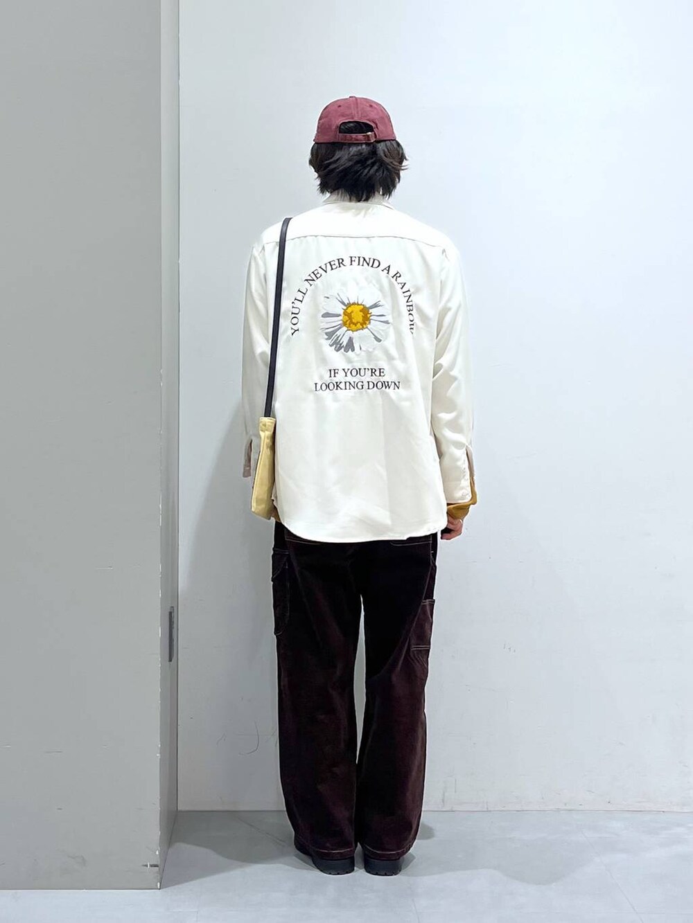 イエロー系のTシャツ/カットソー、ブラウン系のその他パンツ、ベージュ系のショルダーバッグを着用したメンズの冬コーディネートの3枚目の写真