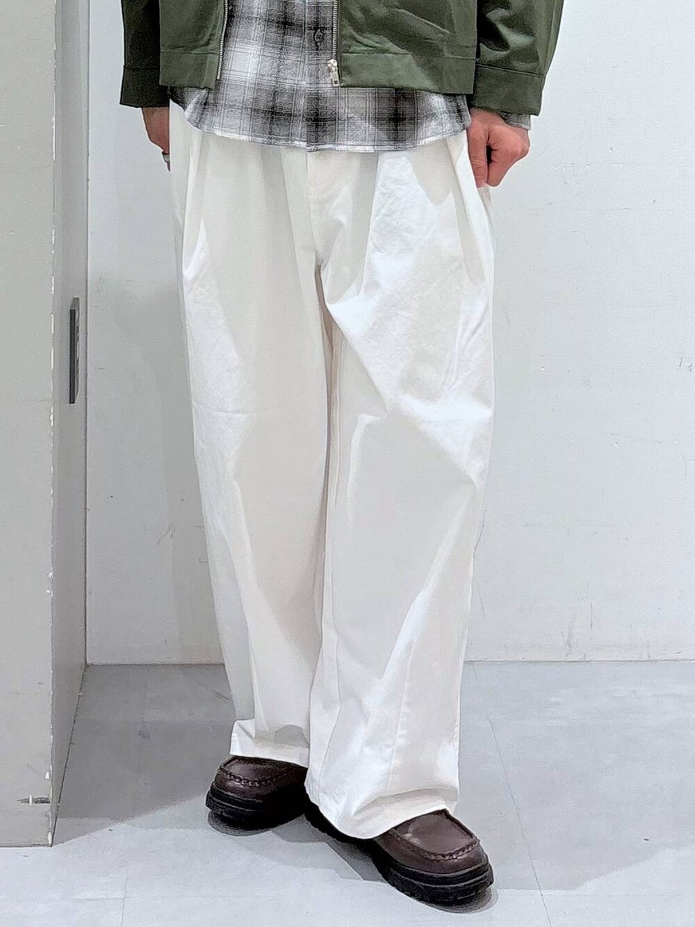 ホワイト系のチノパンツ、ブラック系のシャツ/ブラウス、グリーン系のブルゾンを着用したメンズの冬コーディネートの5枚目の写真