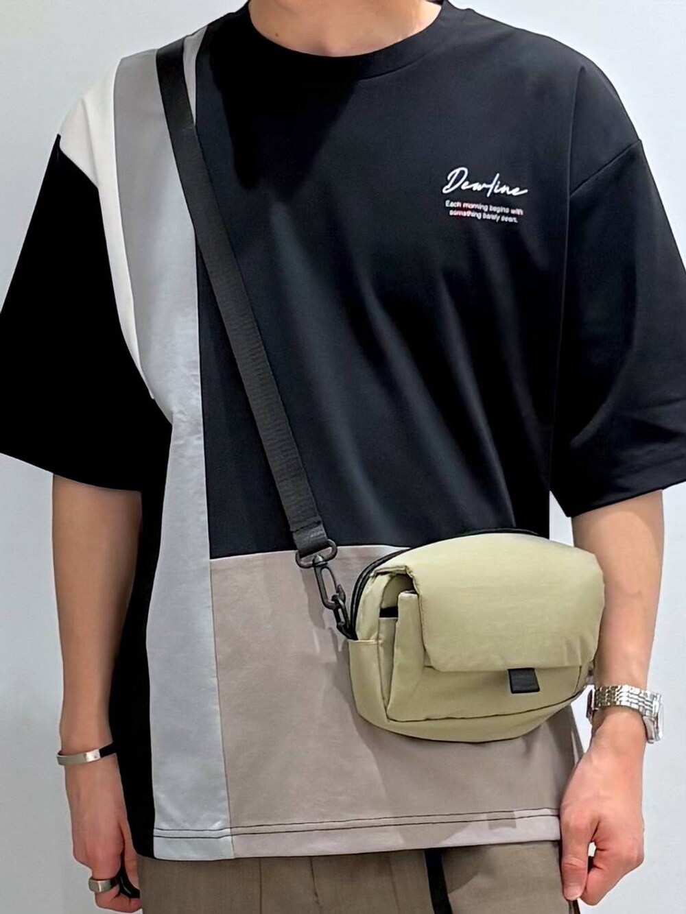 ベージュ系のショルダーバッグ、ブラック系のTシャツ/カットソー、グレー系のその他パンツを着用したメンズの春コーディネートの4枚目の写真