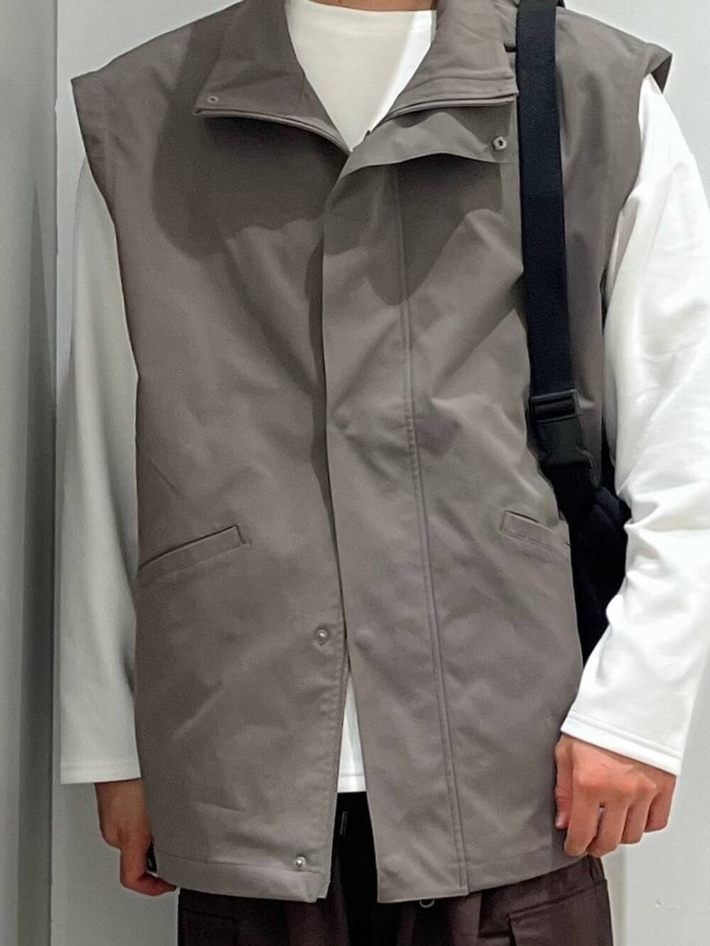 ホワイト系のTシャツ/カットソー、ブラウン系のカーゴパンツ、グレー系のブルゾンを着用したメンズの秋コーディネートの4枚目の写真