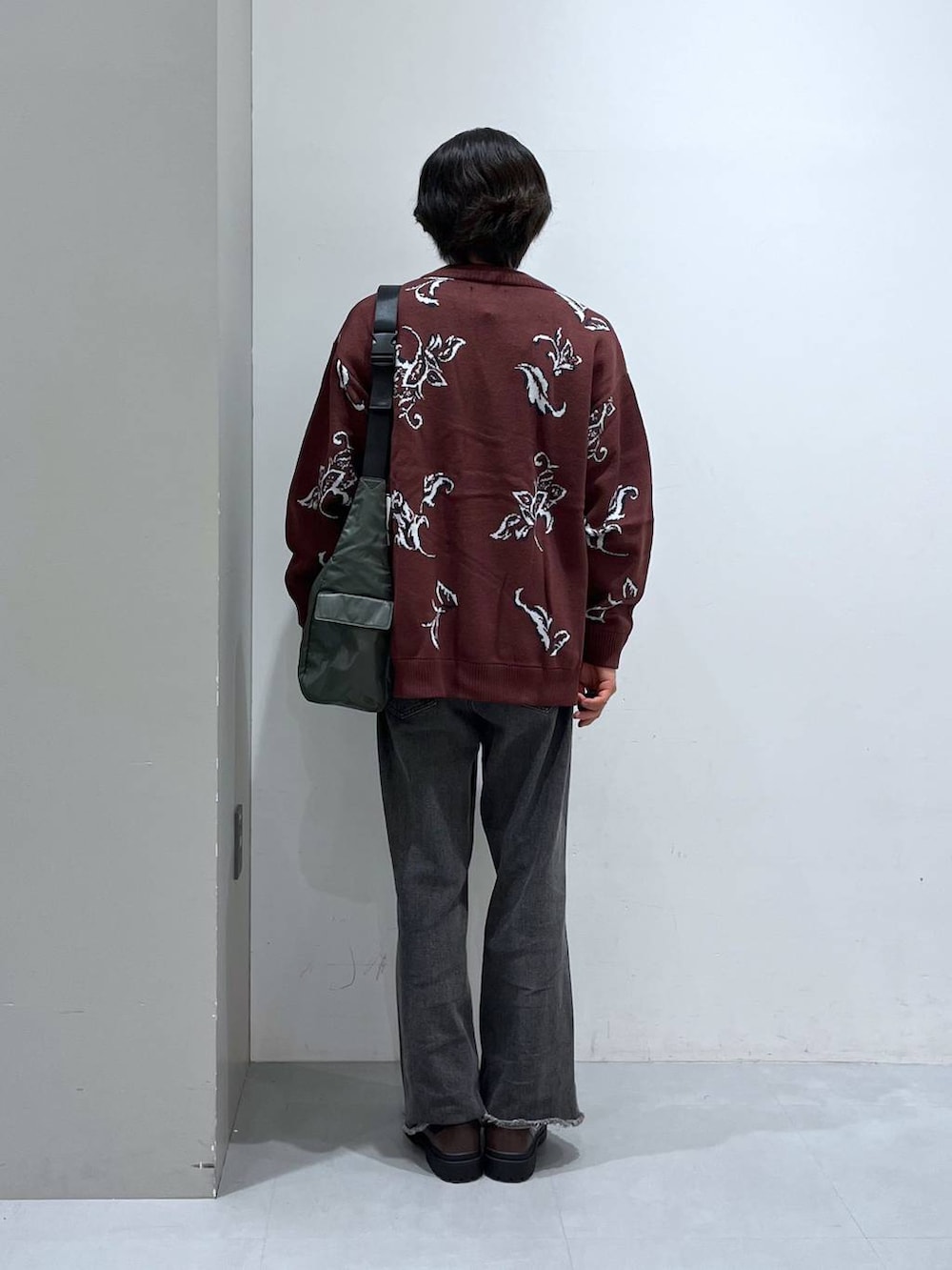 グリーン系のショルダーバッグ、グレー系のデニムパンツ、ブラウン系のローファーを着用したメンズの秋コーディネートの3枚目の写真