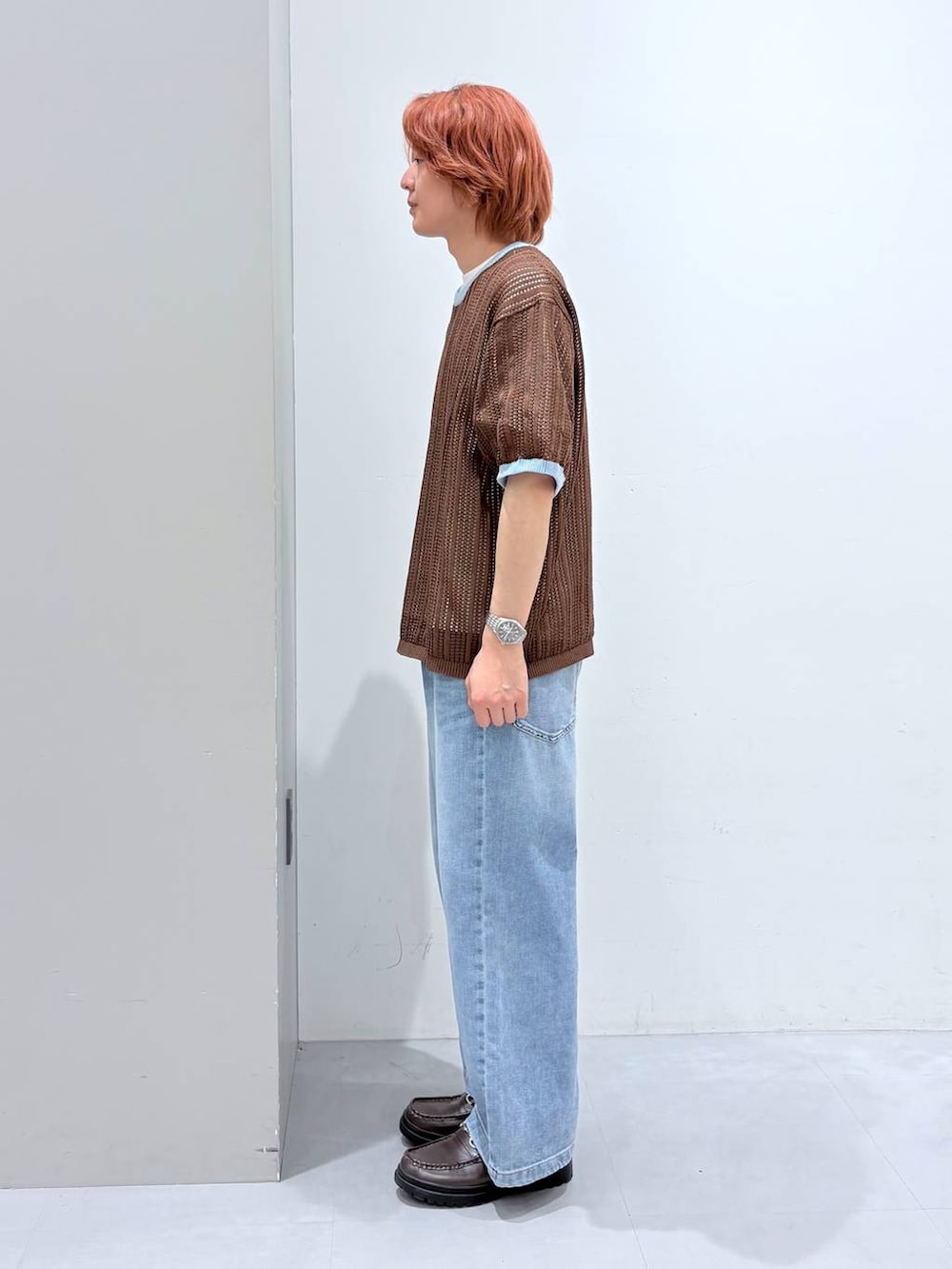 ホワイト系のTシャツ/カットソー、ブルー系のデニムパンツ、ブラウン系のニット/セーターを着用したメンズの春コーディネートの2枚目の写真