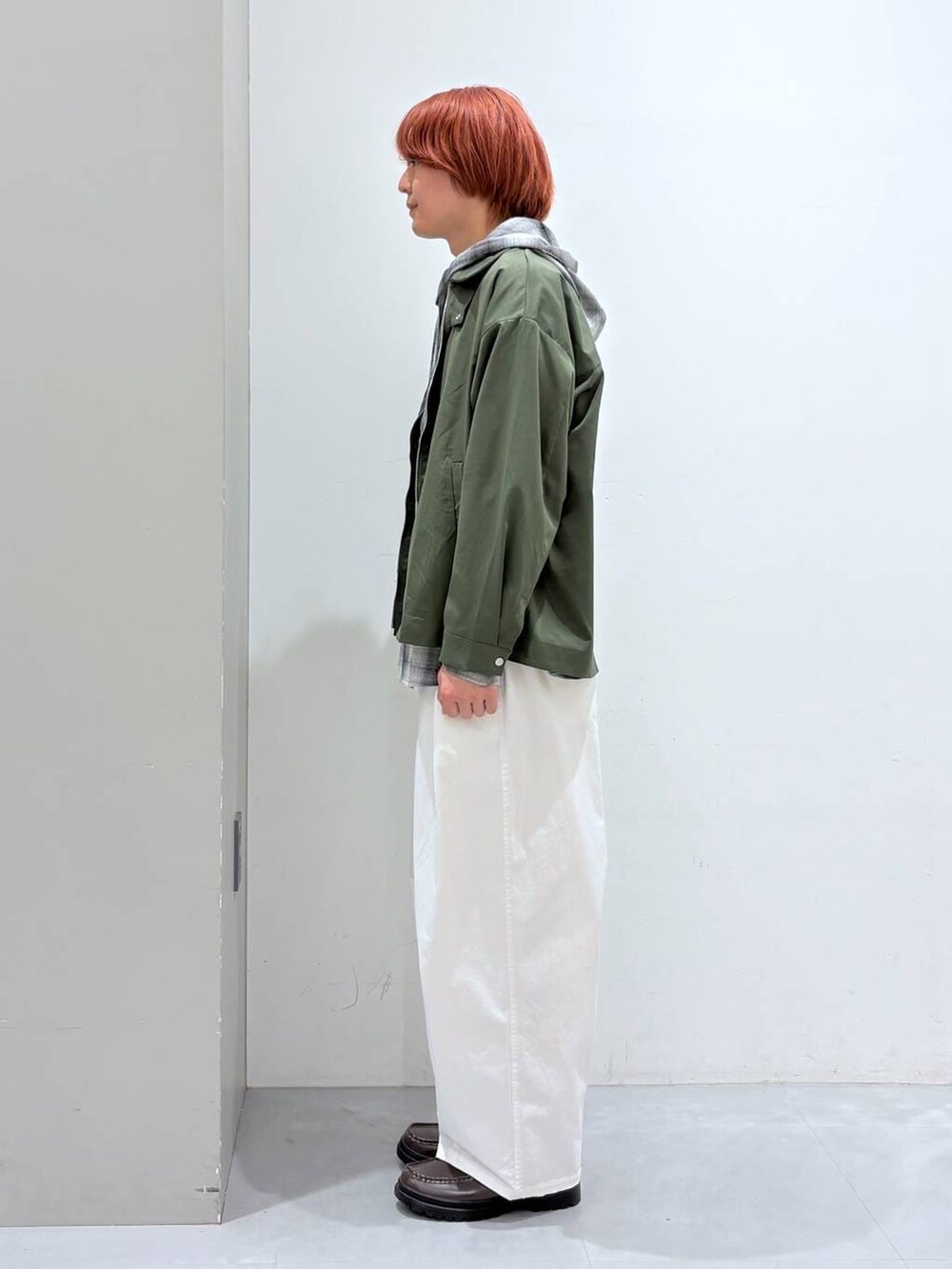 ホワイト系のチノパンツ、ブラック系のシャツ/ブラウス、グリーン系のブルゾンを着用したメンズの冬コーディネートの2枚目の写真