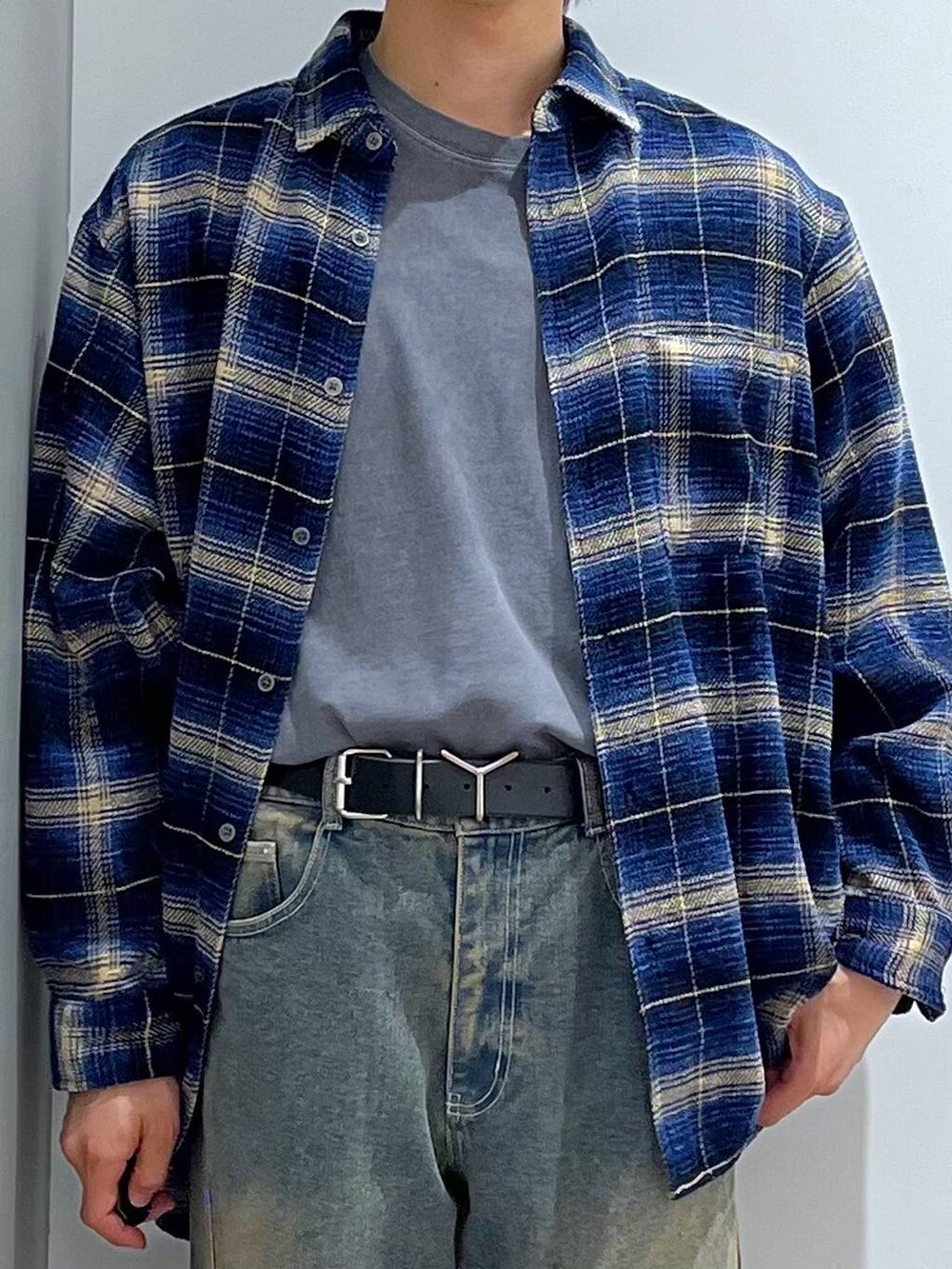 グレー系のTシャツ/カットソー、ブルー系のデニムパンツ、ブラック系のローファーを着用したメンズの秋コーディネートの4枚目の写真