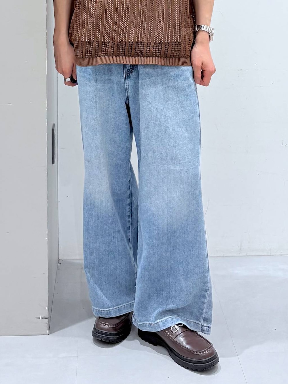 ホワイト系のTシャツ/カットソー、ブルー系のデニムパンツ、ブラウン系のニット/セーターを着用したメンズの春コーディネートの5枚目の写真