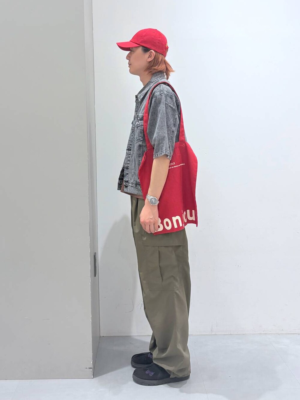 レッド系のトートバッグ、ブラック系のシャツ/ブラウス、ブラウン系のTシャツ/カットソーを着用したメンズの春コーディネートの2枚目の写真