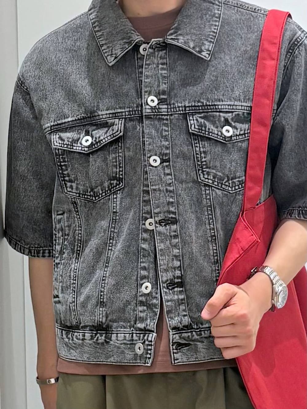 レッド系のトートバッグ、ブラック系のシャツ/ブラウス、ブラウン系のTシャツ/カットソーを着用したメンズの春コーディネートの4枚目の写真