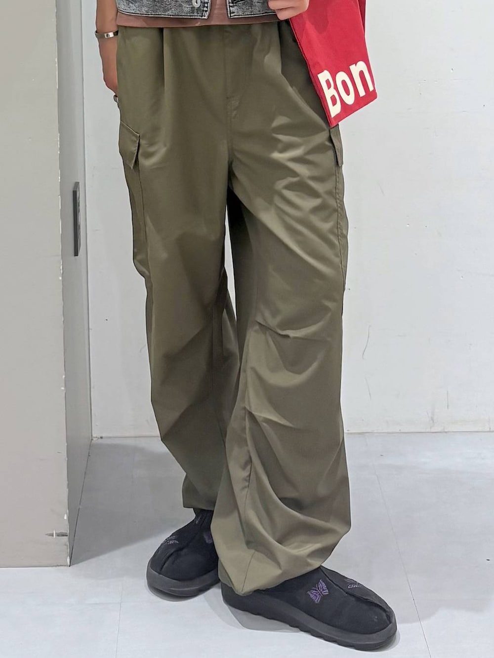 レッド系のトートバッグ、ブラック系のシャツ/ブラウス、ブラウン系のTシャツ/カットソーを着用したメンズの春コーディネートの5枚目の写真