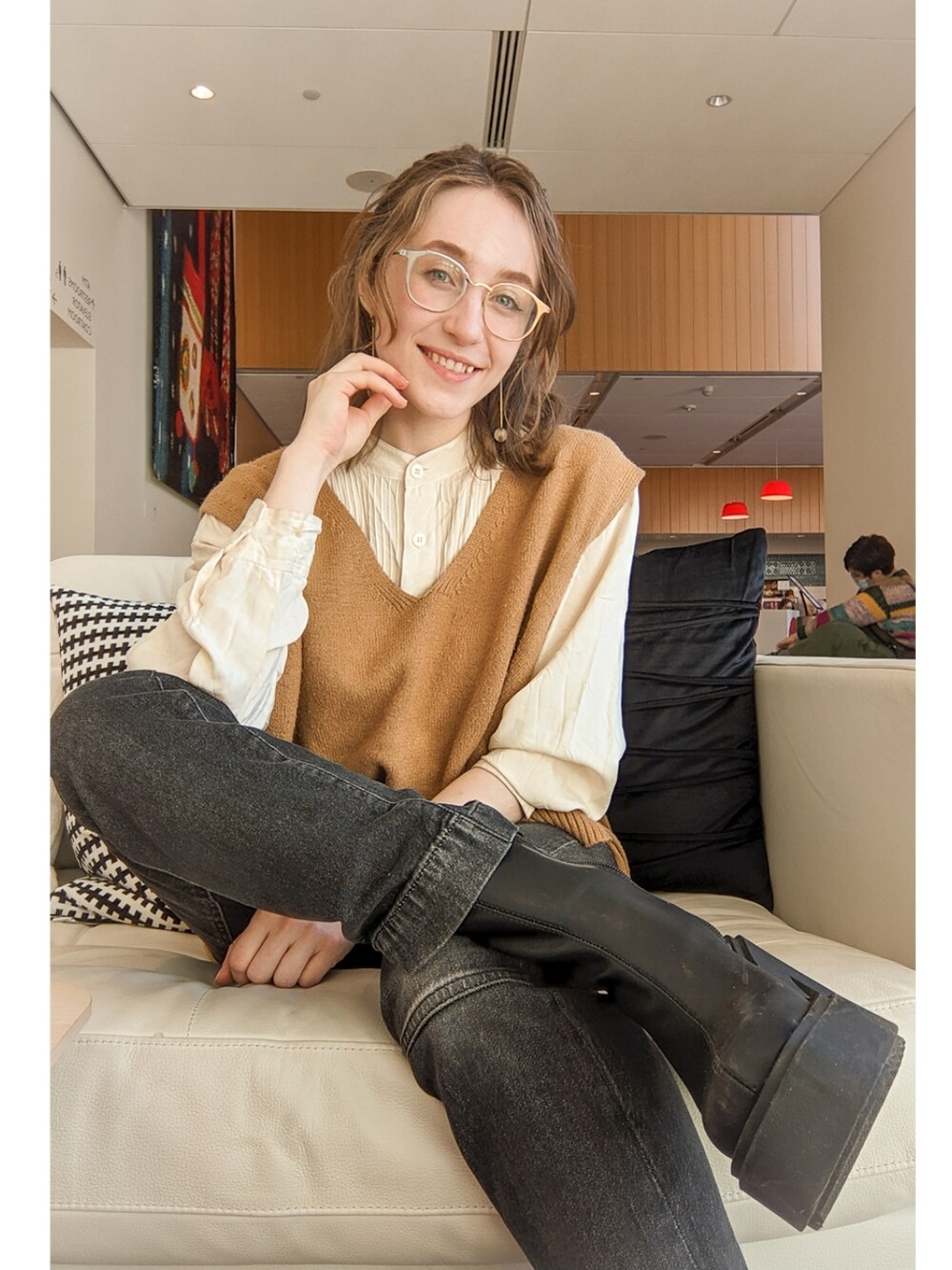 ゴールド系のベスト、ブラック系のデニムパンツ、ブラック系のブーツを着用したレディースの春コーディネートの2枚目の写真