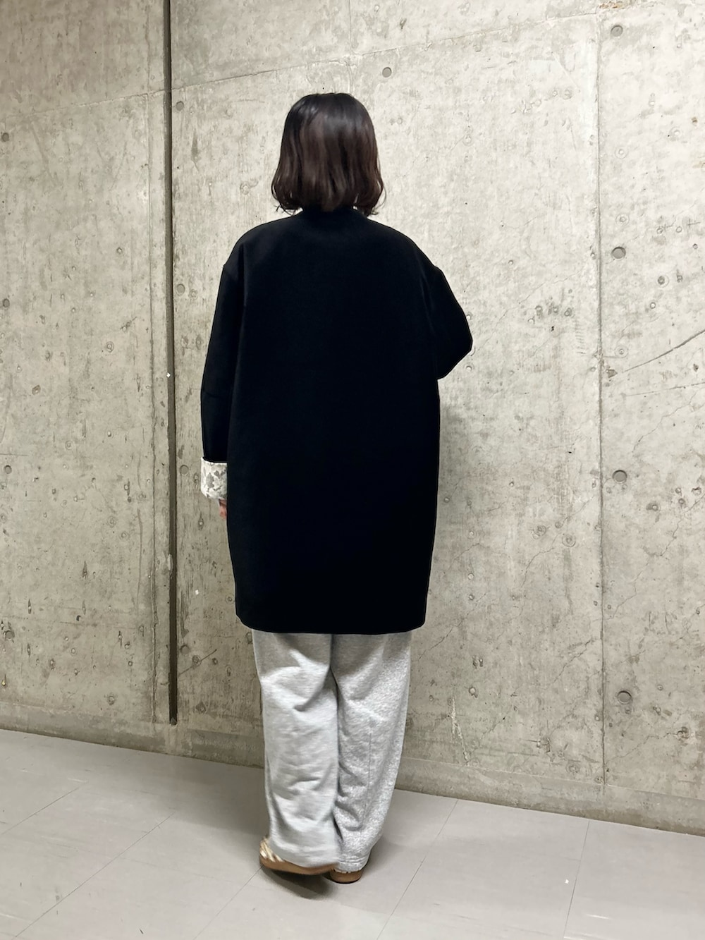 ブラック系のその他アウター、ブラウン系のTシャツ/カットソー、グレー系のその他パンツを着用したレディースの秋コーディネートの2枚目の写真