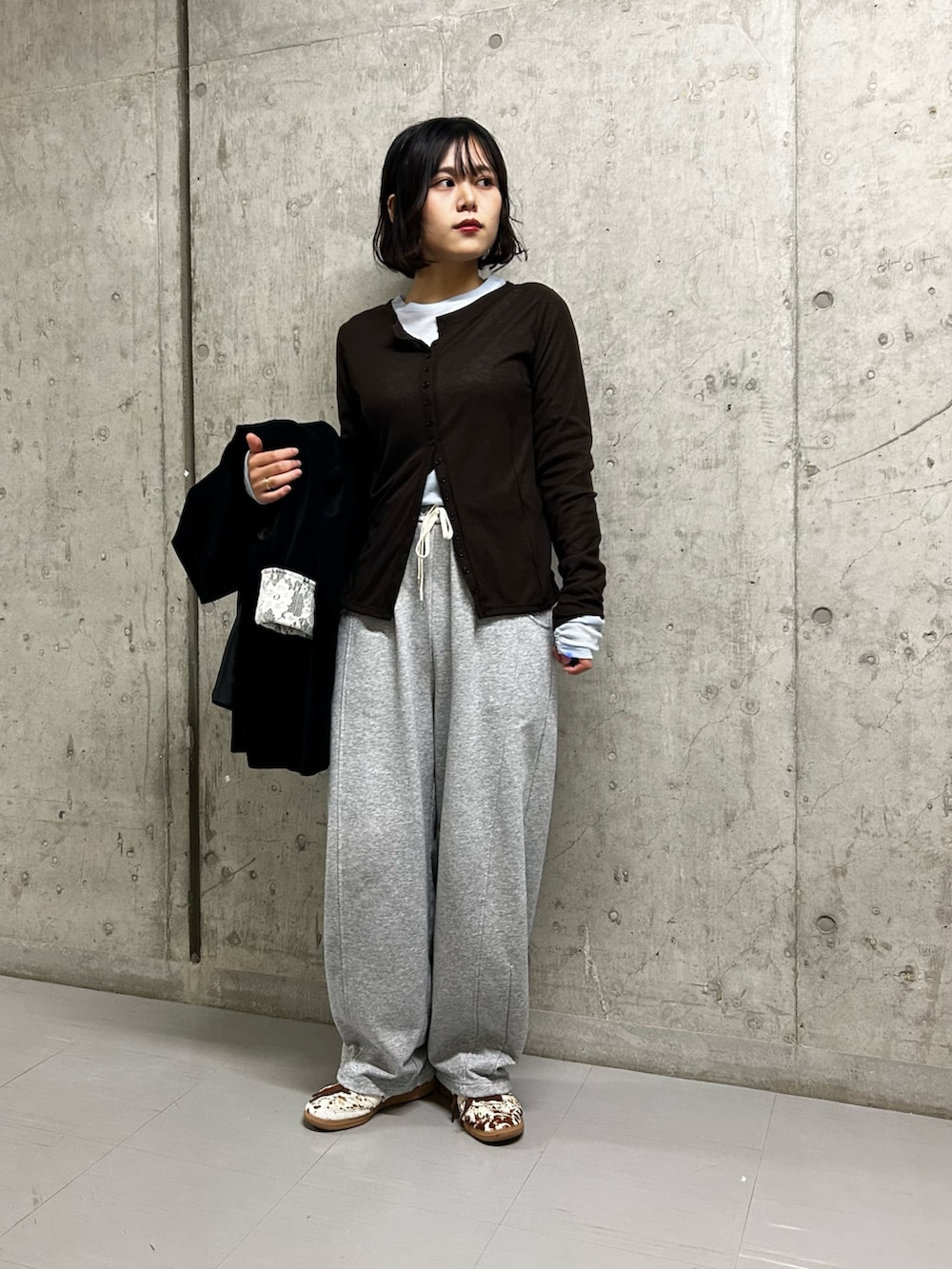 ブラック系のその他アウター、ブラウン系のTシャツ/カットソー、グレー系のその他パンツを着用したレディースの秋コーディネートの5枚目の写真