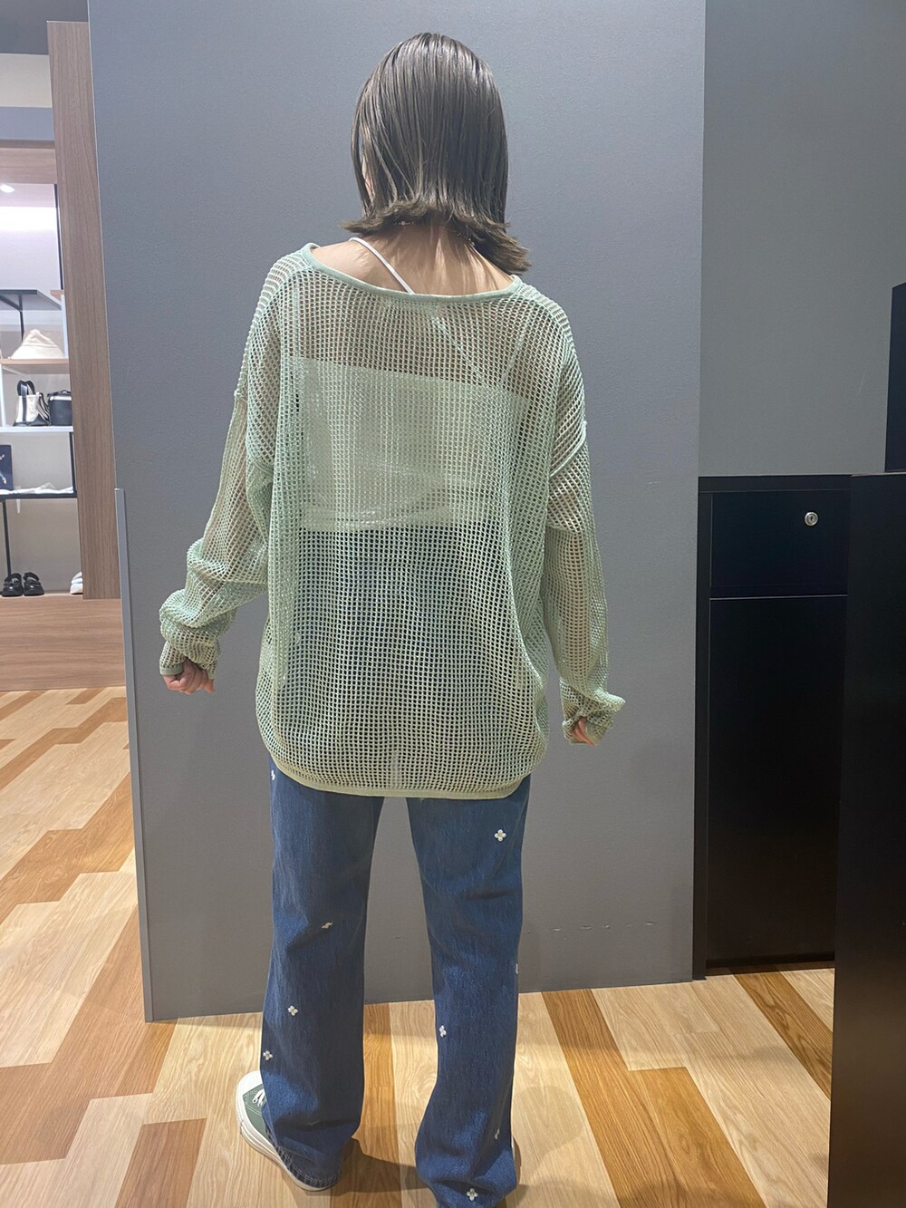 ブルー系のデニムパンツ、グリーン系のスニーカー、グリーン系のカーディガン/ボレロを着用したレディースの春コーディネートの2枚目の写真