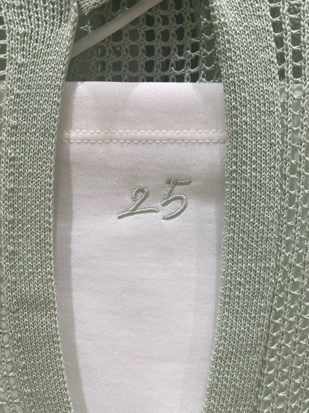 ブルー系のデニムパンツ、グリーン系のスニーカー、グリーン系のカーディガン/ボレロを着用したレディースの春コーディネートの3枚目の写真