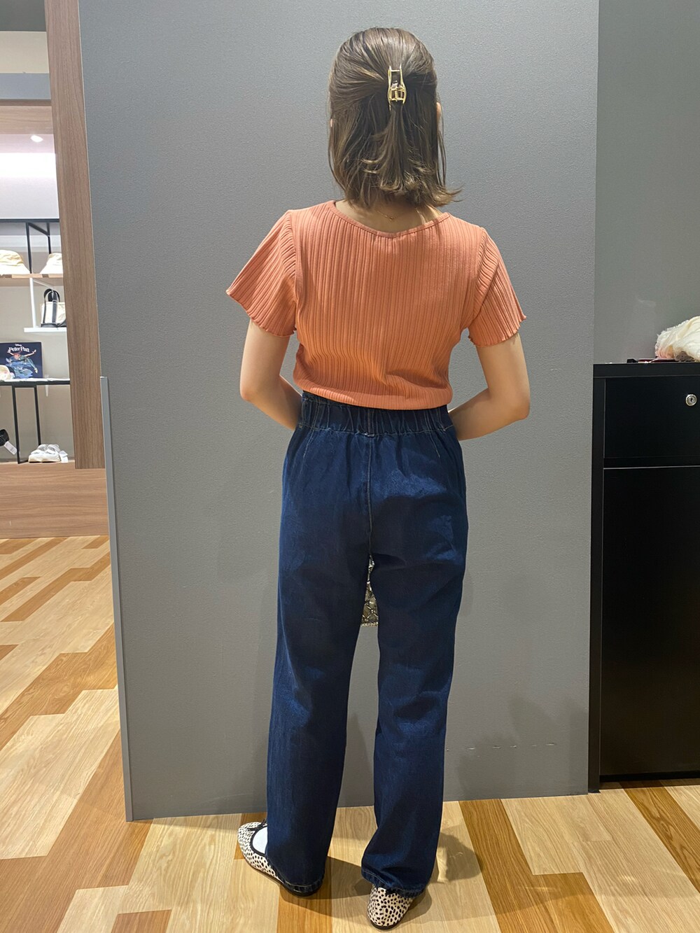 オレンジ系のTシャツ/カットソー、ブルー系のデニムパンツ、ブルー系のハンドバッグを着用したレディースの春コーディネートの2枚目の写真