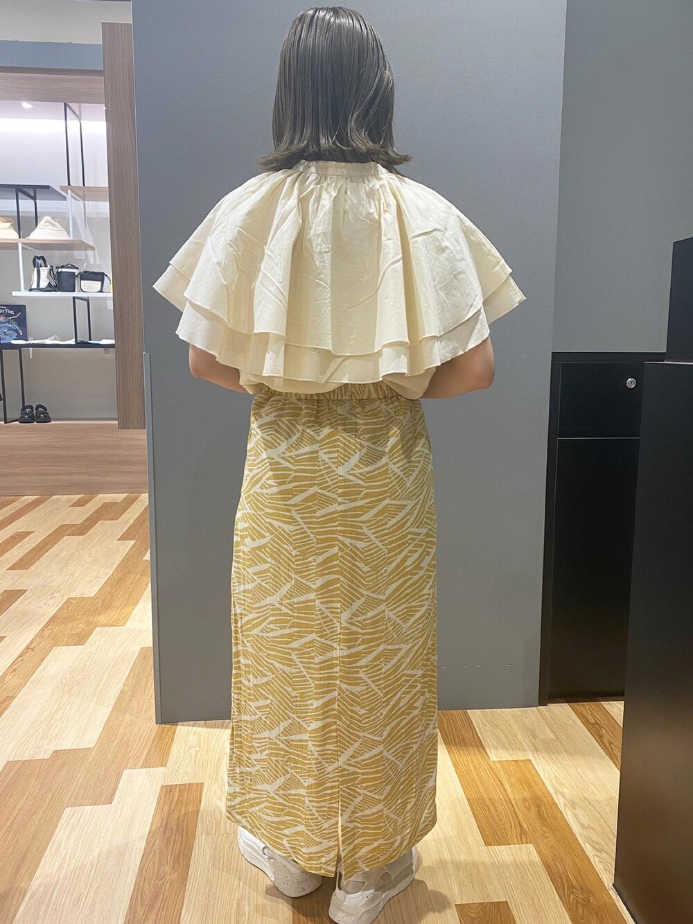 ホワイト系のシャツ/ブラウス、ホワイト系のエコバッグ/サブバッグ、イエロー系のスカートを着用したレディースの春コーディネートの2枚目の写真