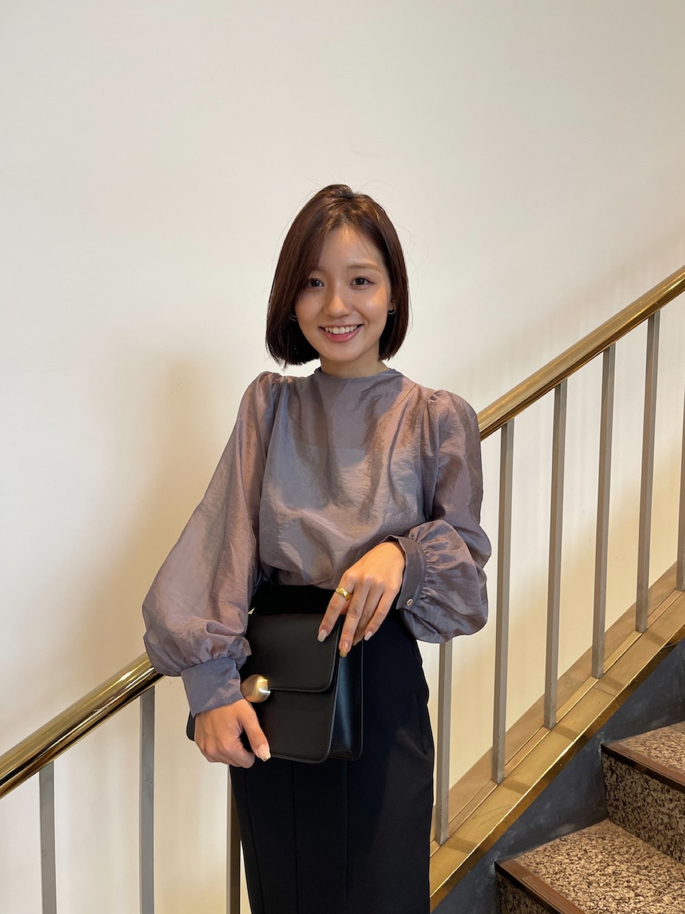 グレー系のシャツ/ブラウス、ブラック系のスカート、ブラック系のハンドバッグを着用したレディースの秋コーディネートの2枚目の写真