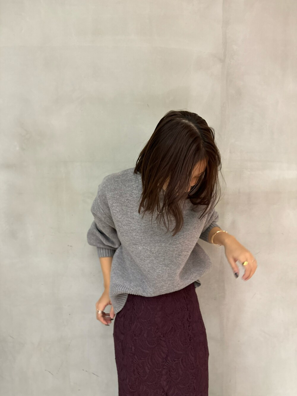 グレー系のニット/セーター、レッド系のスカート、ブラウン系のパンプスを着用したレディースの秋コーディネートの4枚目の写真