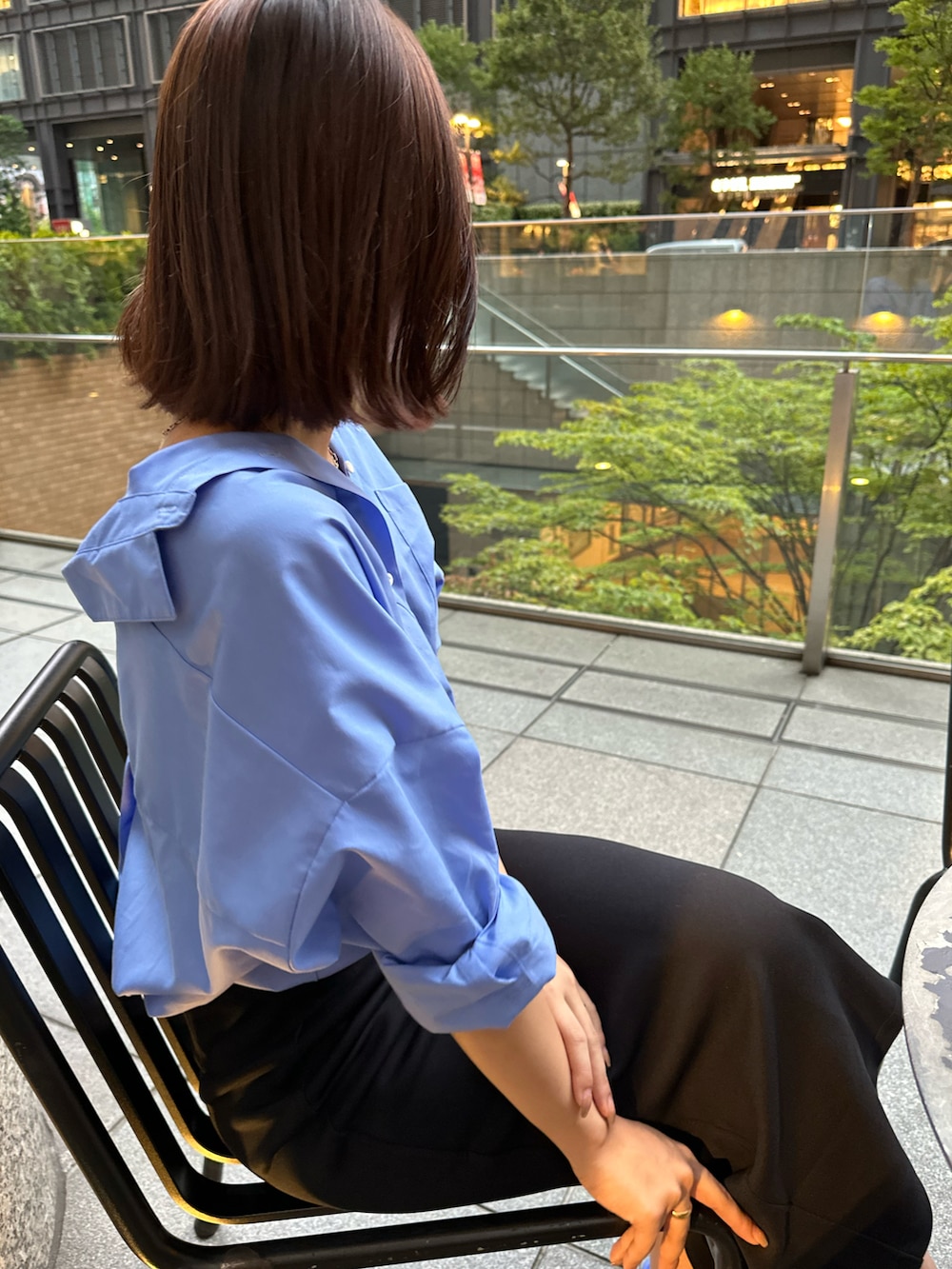 ブラック系のスカート、ブルー系のシャツ/ブラウスを着用したレディースの秋コーディネートの2枚目の写真