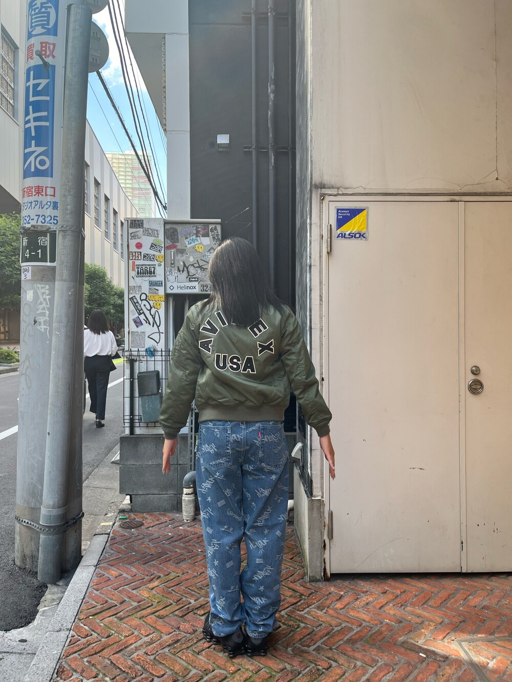 グリーン系のMA-1、ブルー系のデニムパンツを着用したレディースの秋コーディネートの2枚目の写真