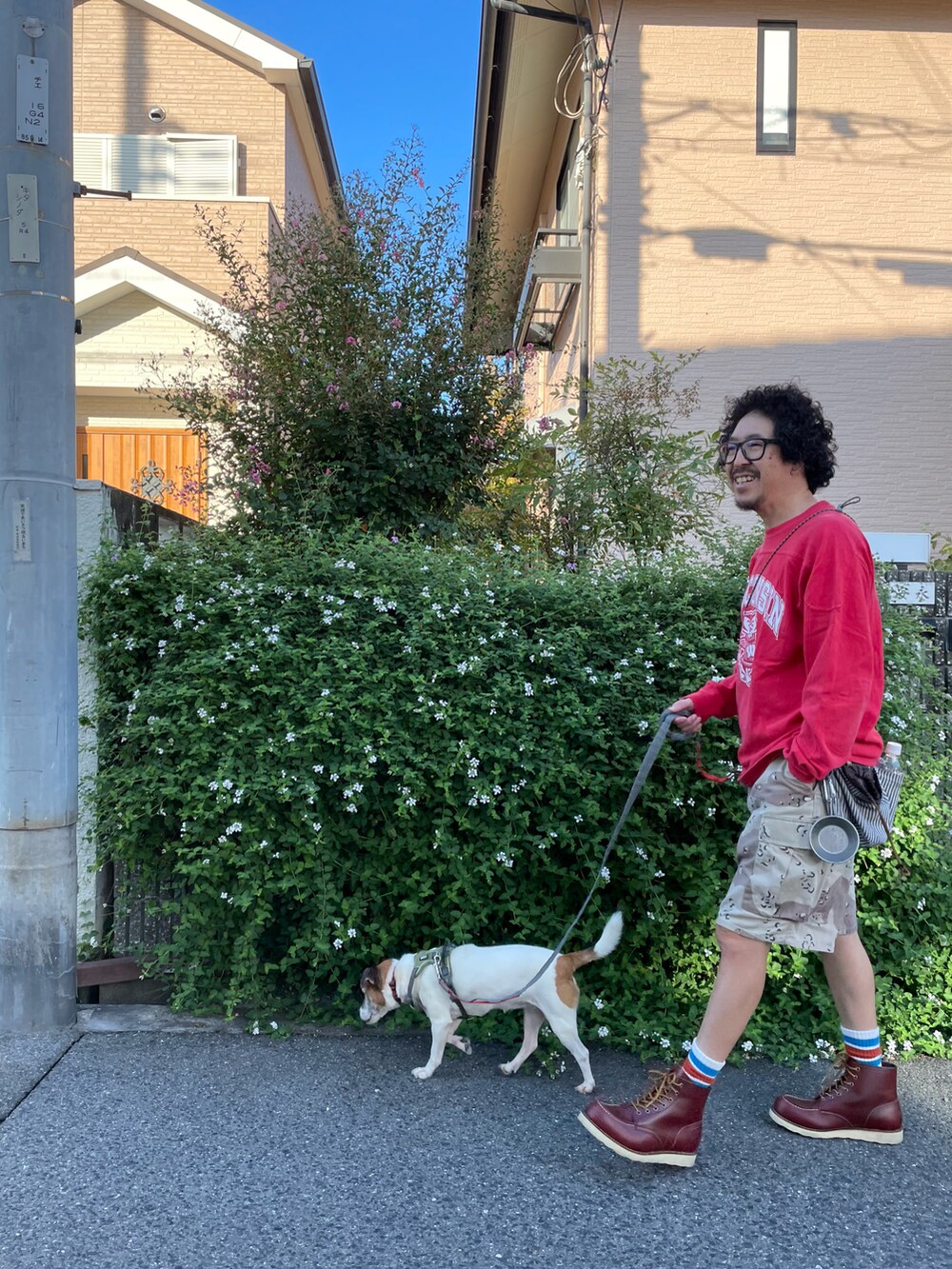 レッド系のTシャツ/カットソー、ベージュ系のカーゴパンツ、ブラウン系のブーツを着用したメンズの秋コーディネートの3枚目の写真