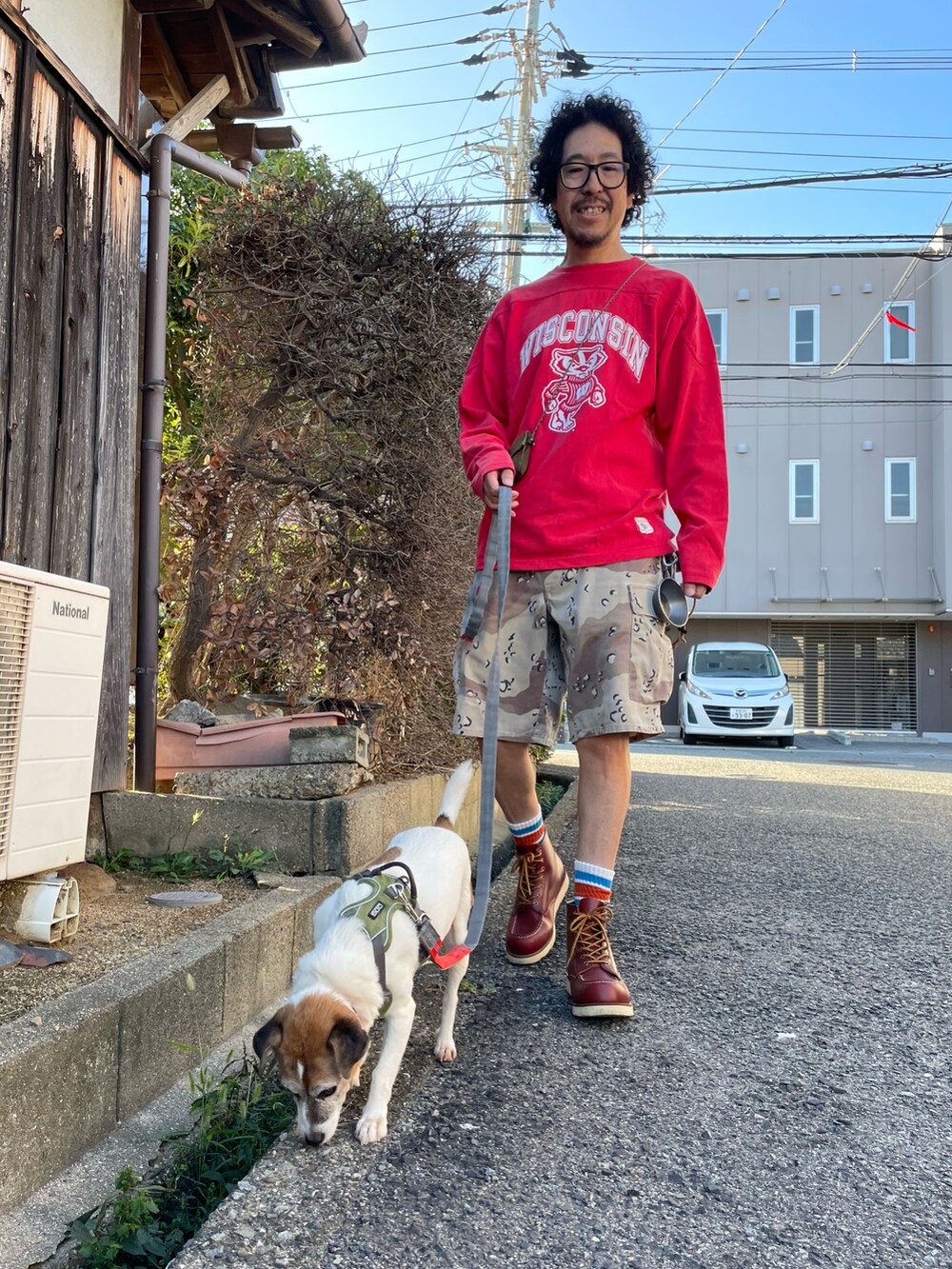 レッド系のTシャツ/カットソー、ベージュ系のカーゴパンツ、ブラウン系のブーツを着用したメンズの秋コーディネートの4枚目の写真