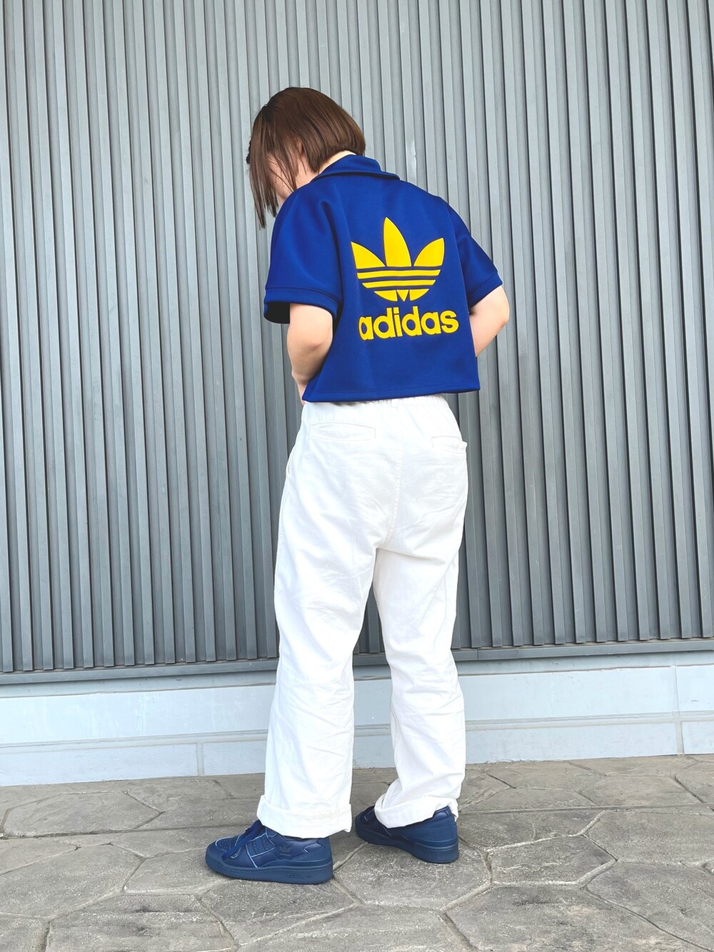 ブルー系のスニーカー、ブルー系のポロシャツを着用したレディースの夏コーディネートの2枚目の写真