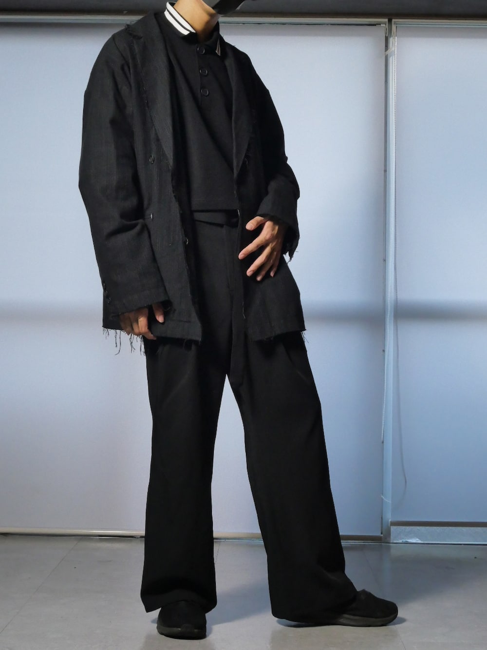 ブラック系のスラックス、ブラック系のポロシャツ、ブラック系のテーラードジャケットを着用したメンズの夏コーディネートの2枚目の写真