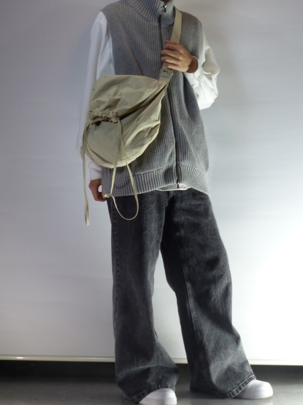 ブラック系のデニムパンツ、ホワイト系のシャツ/ブラウス、グレー系のベストを着用したメンズの春コーディネートの2枚目の写真