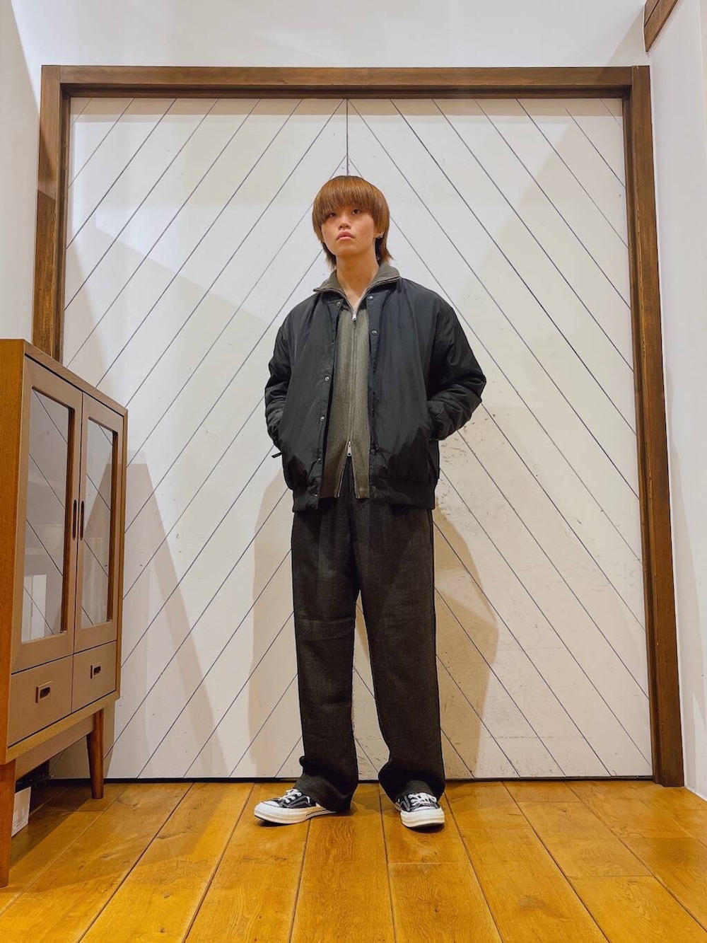 グレー系のニット/セーター、グレー系のその他パンツ、ブラック系のダウンジャケット/コートを着用したメンズの秋コーディネートの2枚目の写真